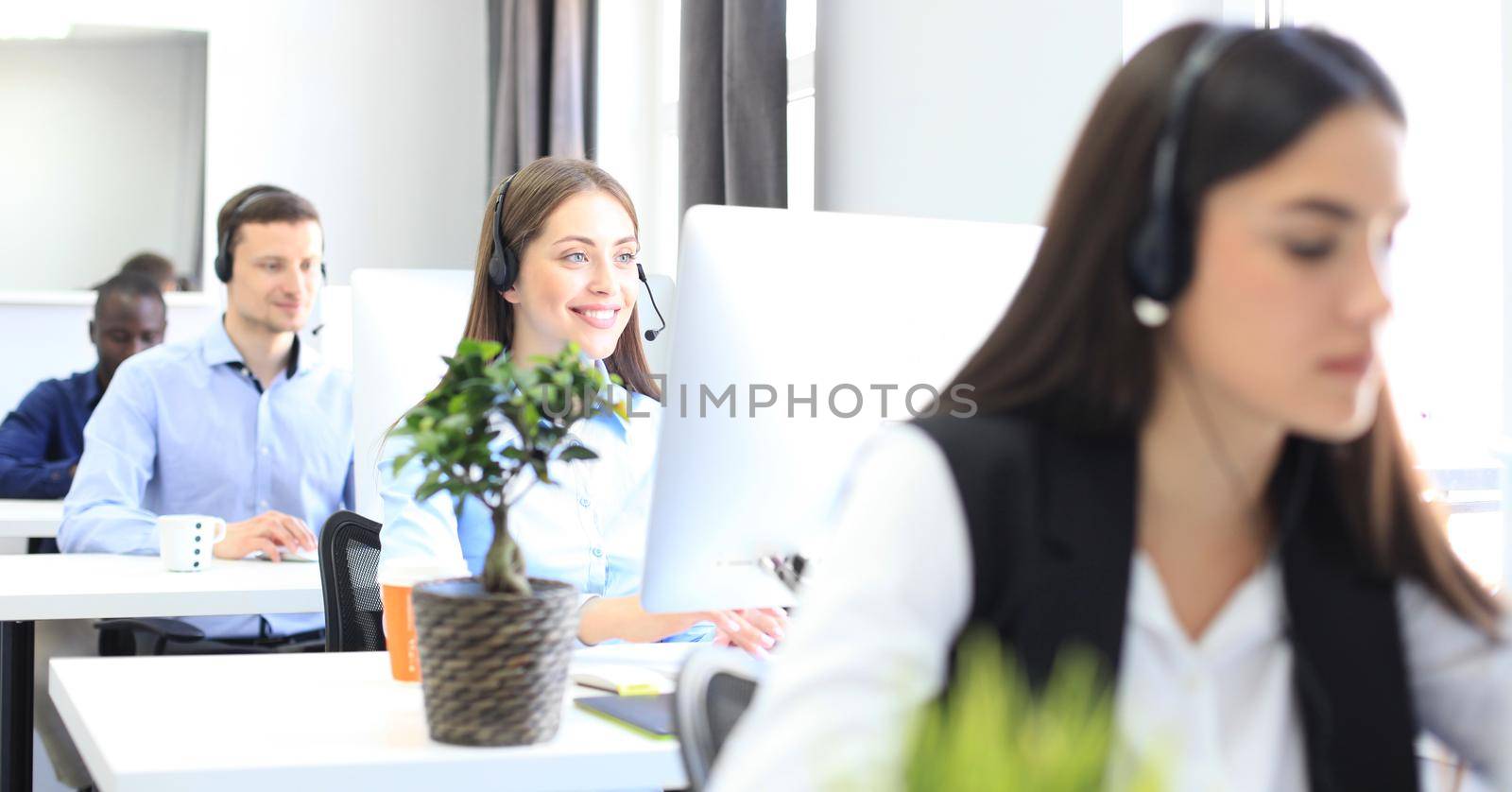 Attractive positive young businesspeople and colleagues in a call center office