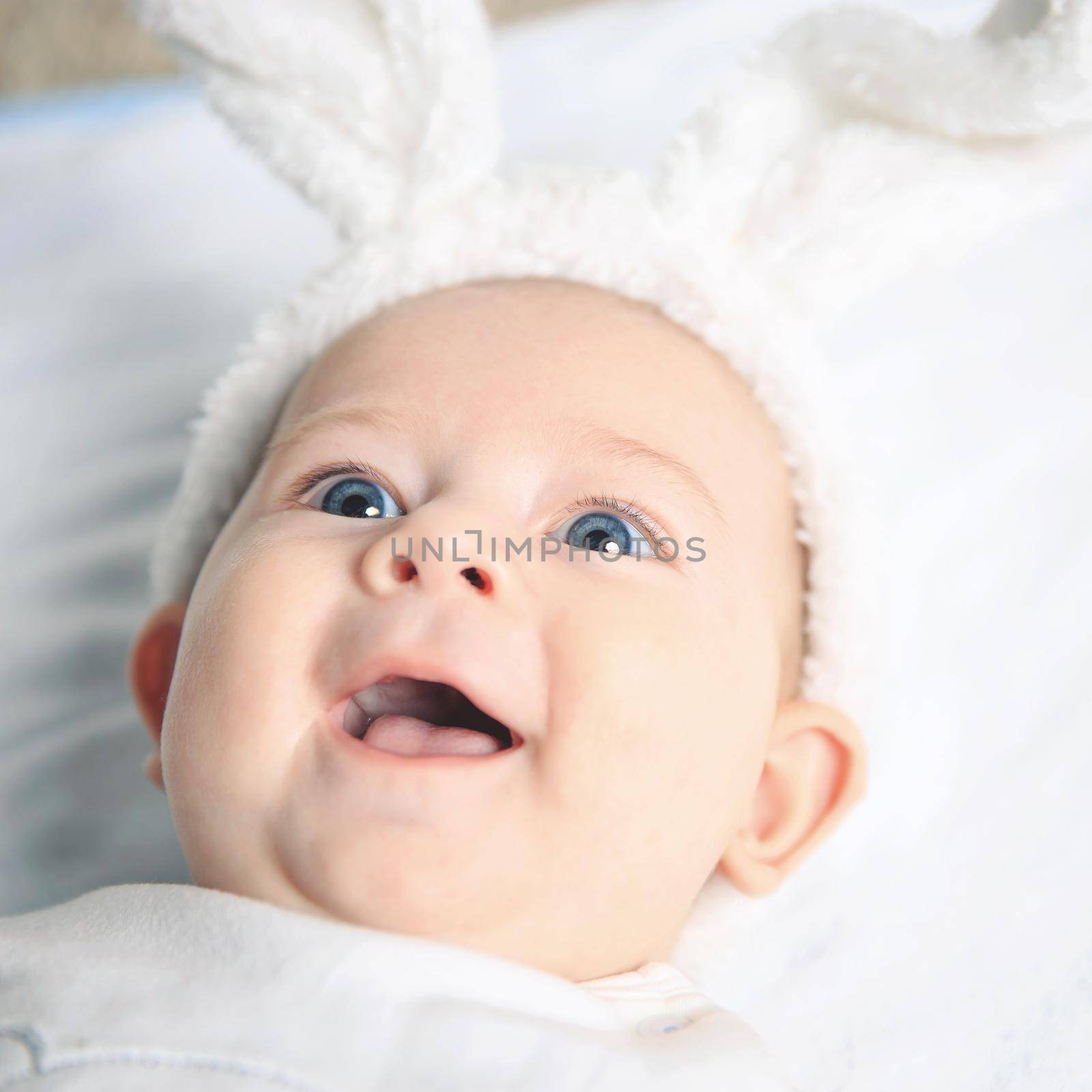Portrait of an adorable baby in a bunny suit, smiling and looking away