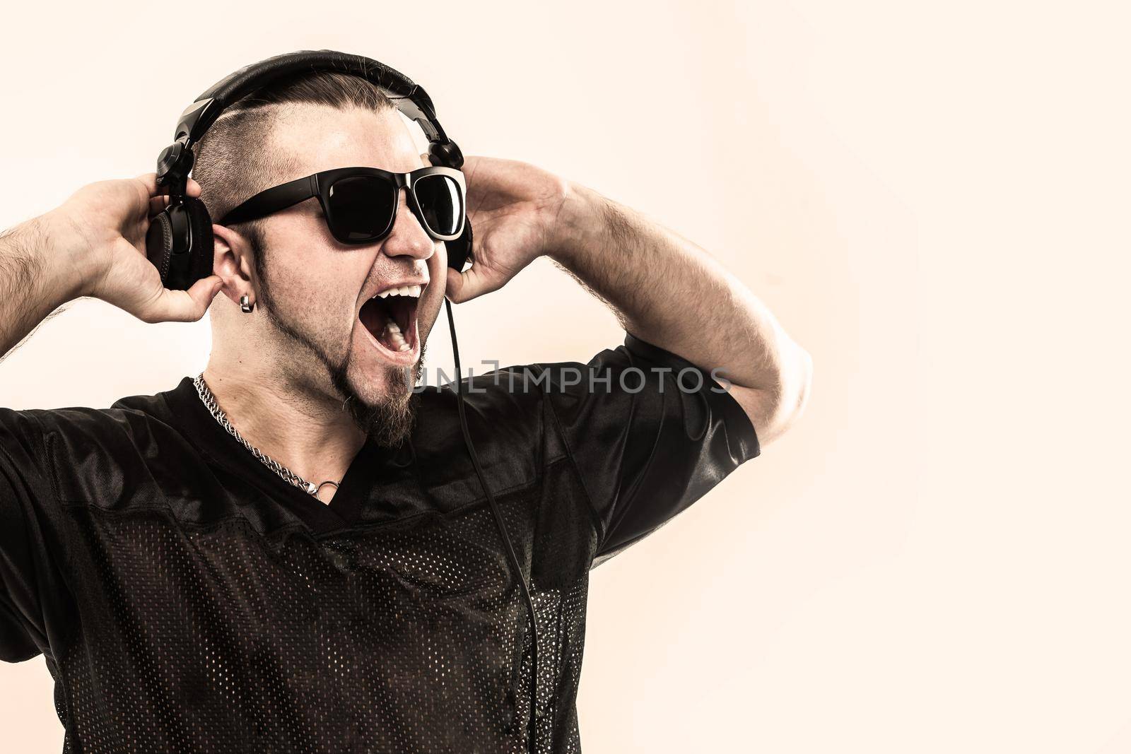 creative rapper in the headphones and dark glasses performs a rap song .photo on a white background and has an empty space for your text