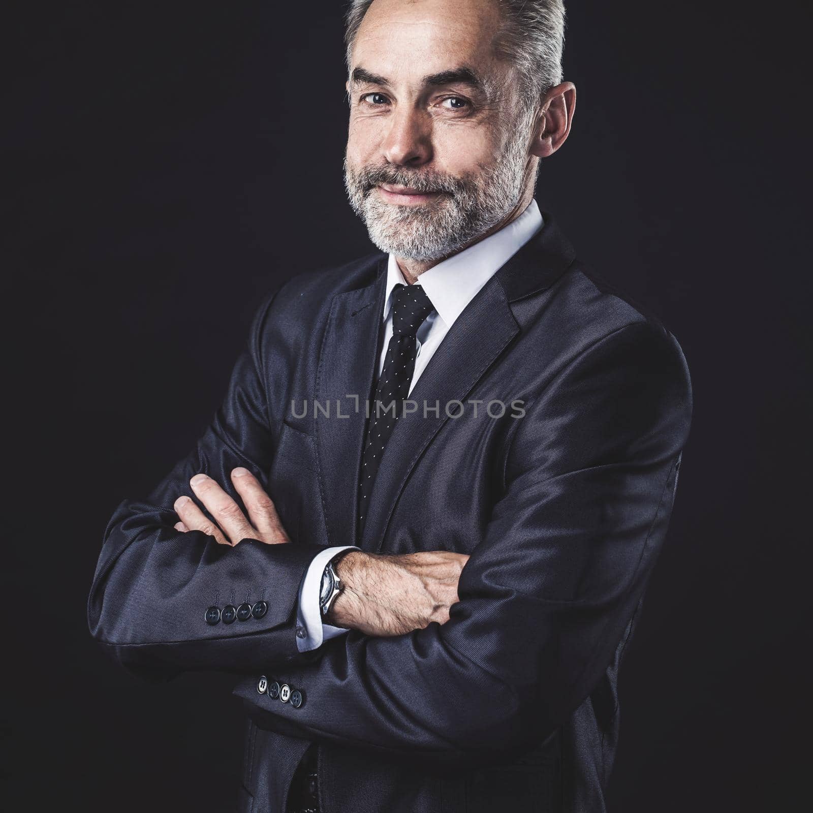 successful businessman with arms crossed on black background.the photo has a empty space for your text