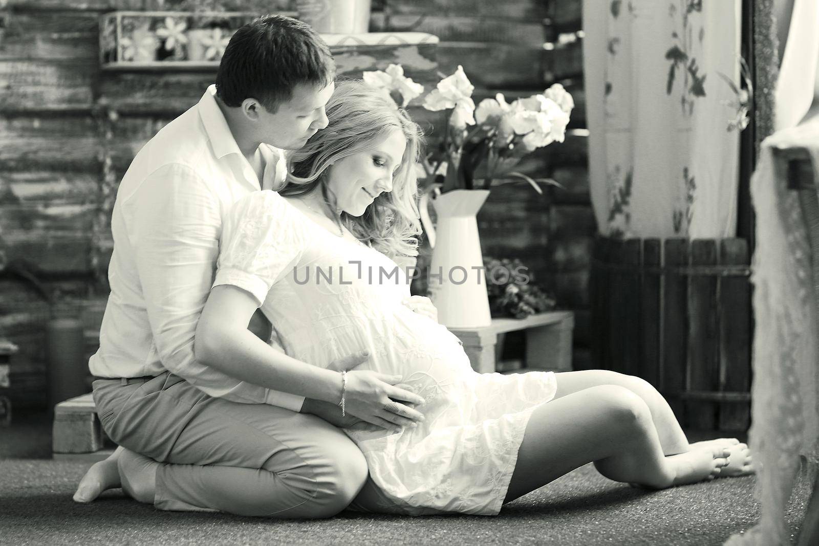 Portrait of a happy couple - husband and pregnant wife, black-and-white photo