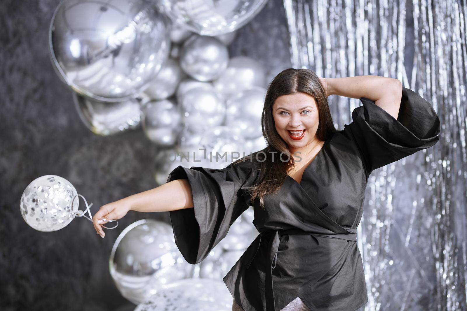 Happy plus size woman dancing at the party 