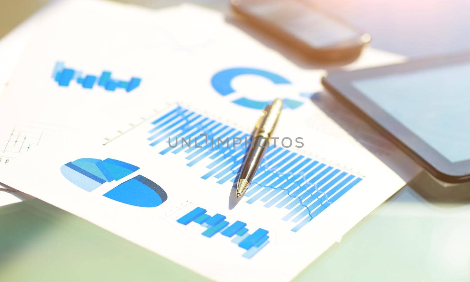 financial charts, tablet and pen on the desktop. by SmartPhotoLab