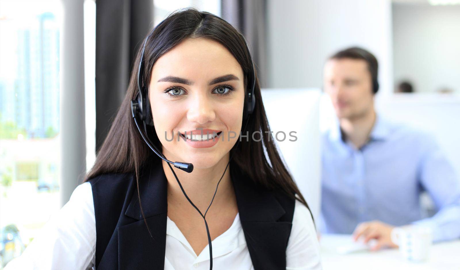 Businesswoman wearing microphone headset using computer in the office - operator, call center. by tsyhun