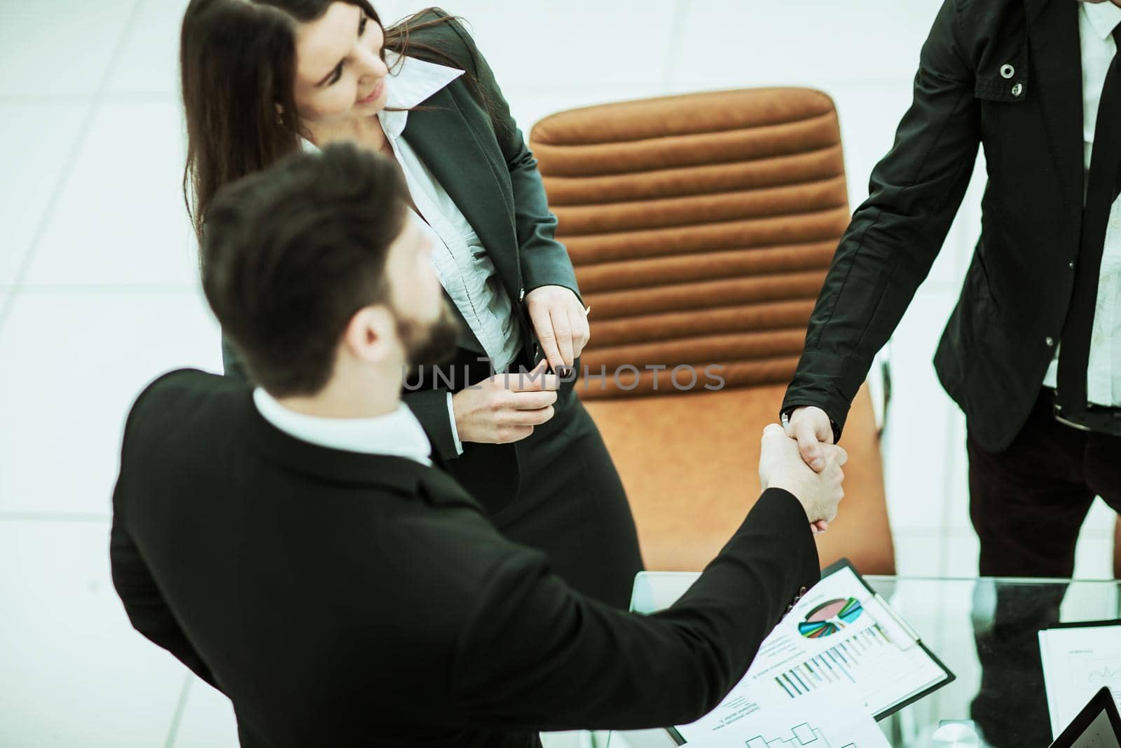 handshake business partners in the workplace in a modern office.