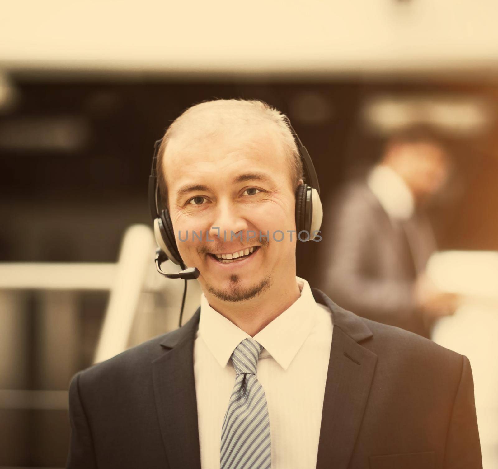 Young customer service operator talking on headset, smiling.