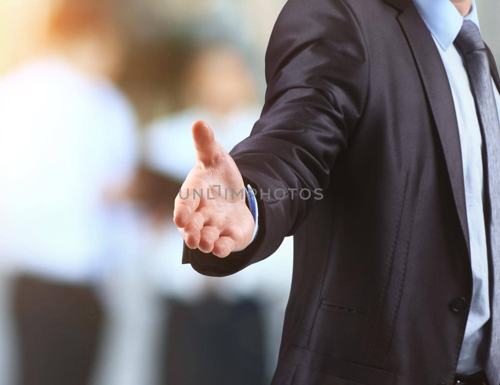 business man with open hand ready to make a deal on blurred background