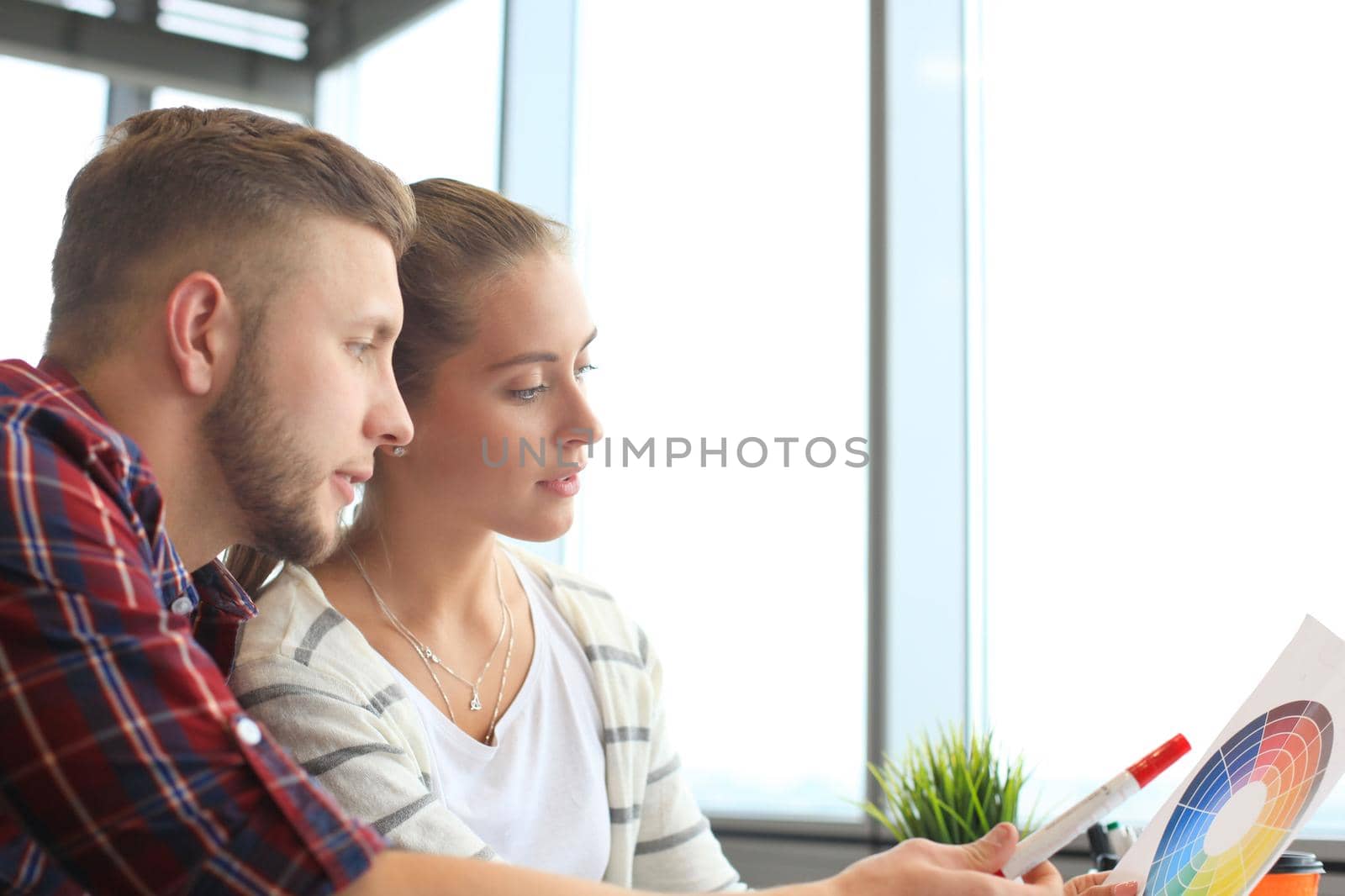 Image of two young business partners discussing plans or ideas at meeting