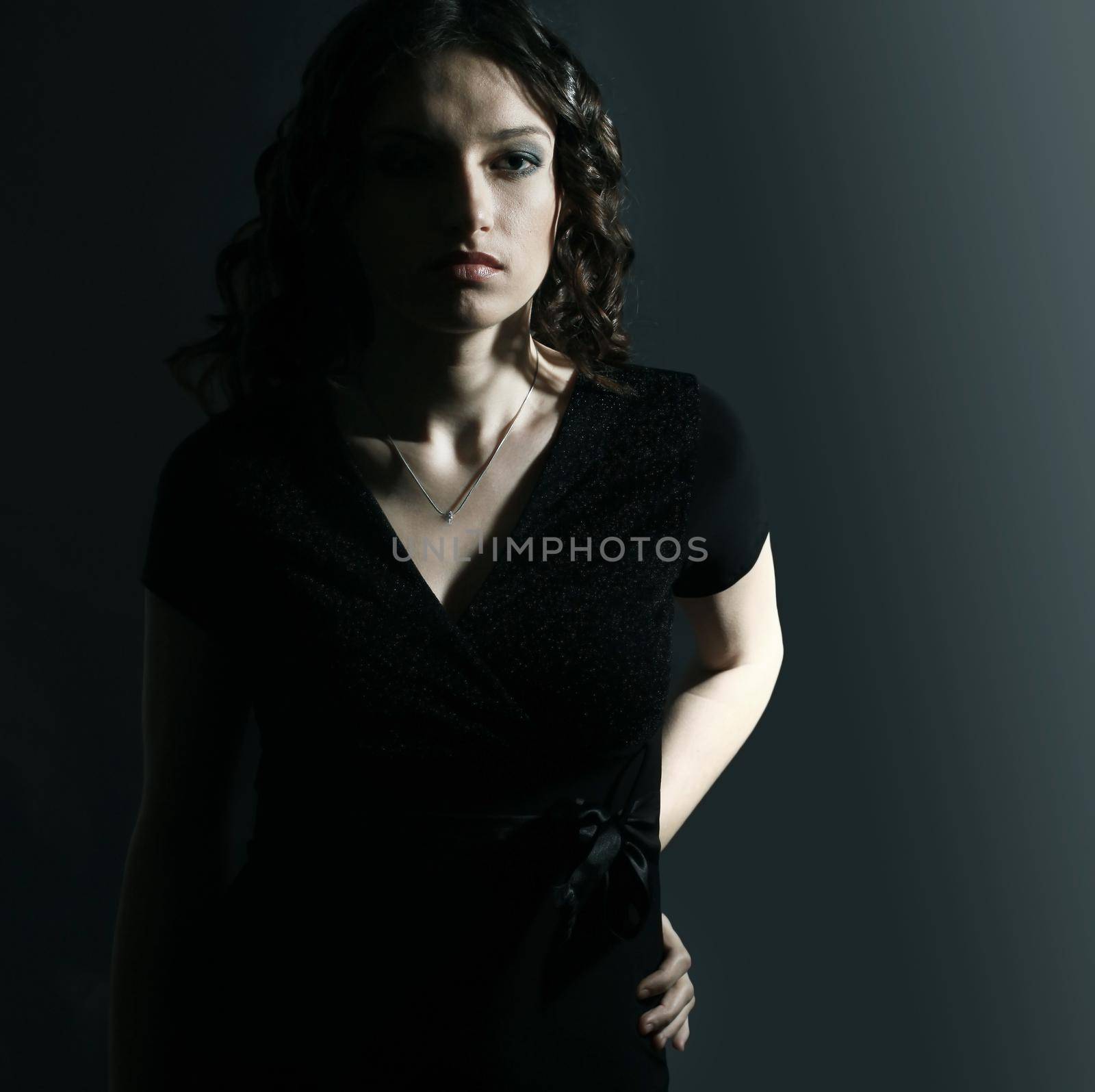 closeup of beautiful young woman in evening black dress.isolated on black background