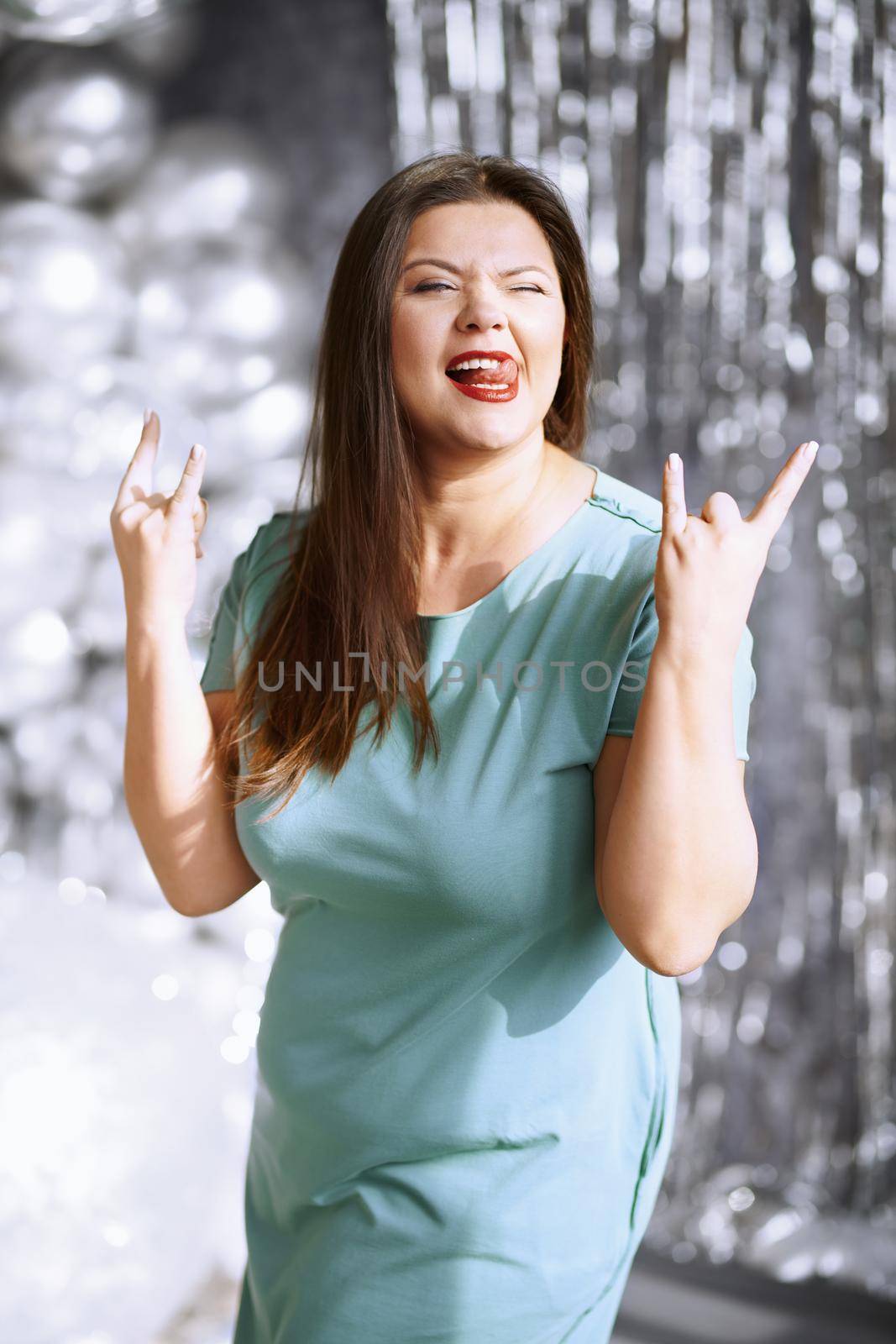 Happy plus size woman showing rock and roll hand gesture