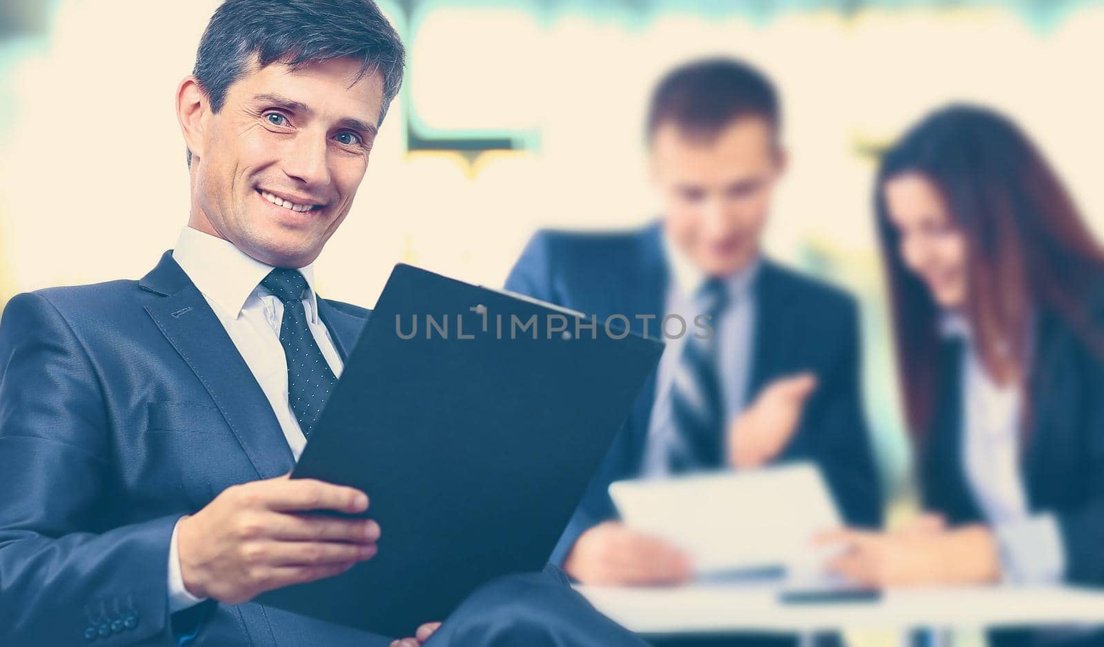 close up.a successful businessman with a clipboard on the background of the office