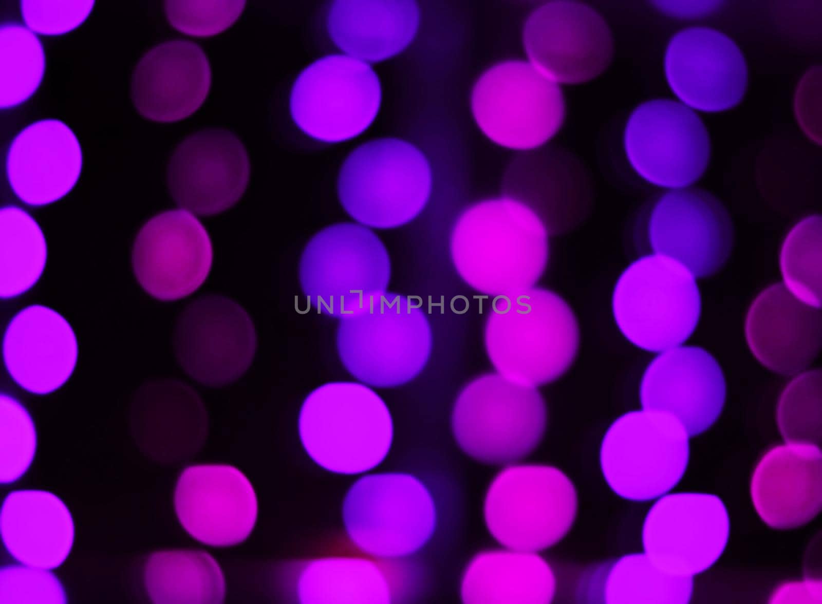 blurred image of purple lights on a black background.festive background