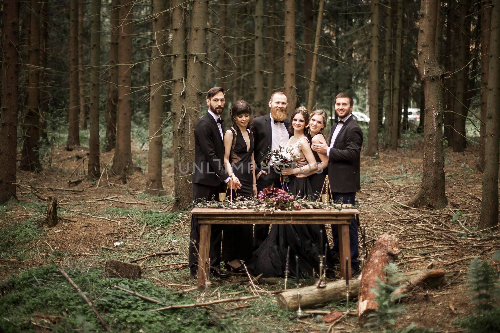 portrait of the couple and the witnesses near the picnic table in the woods