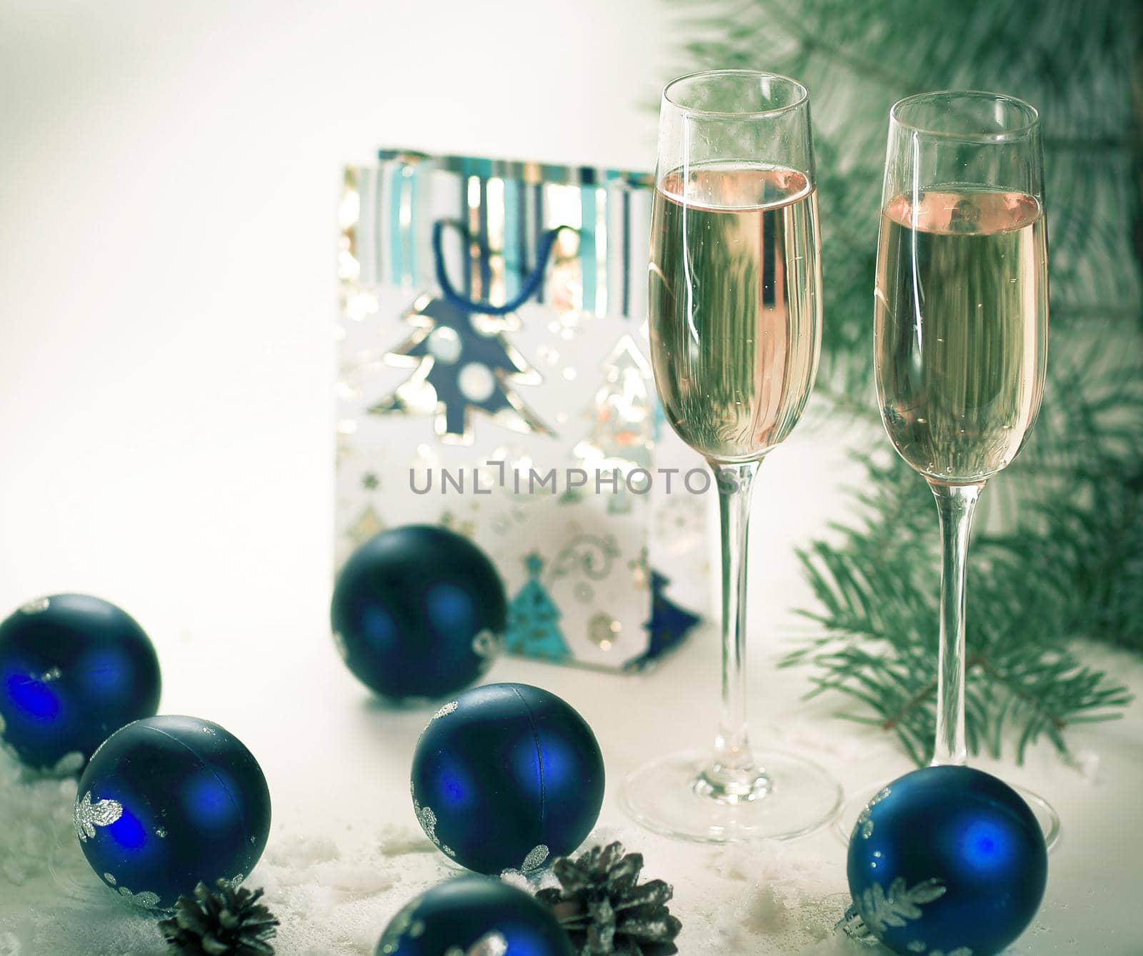 two glasses with champagne and gift on the Christmas background .photo with copy space.