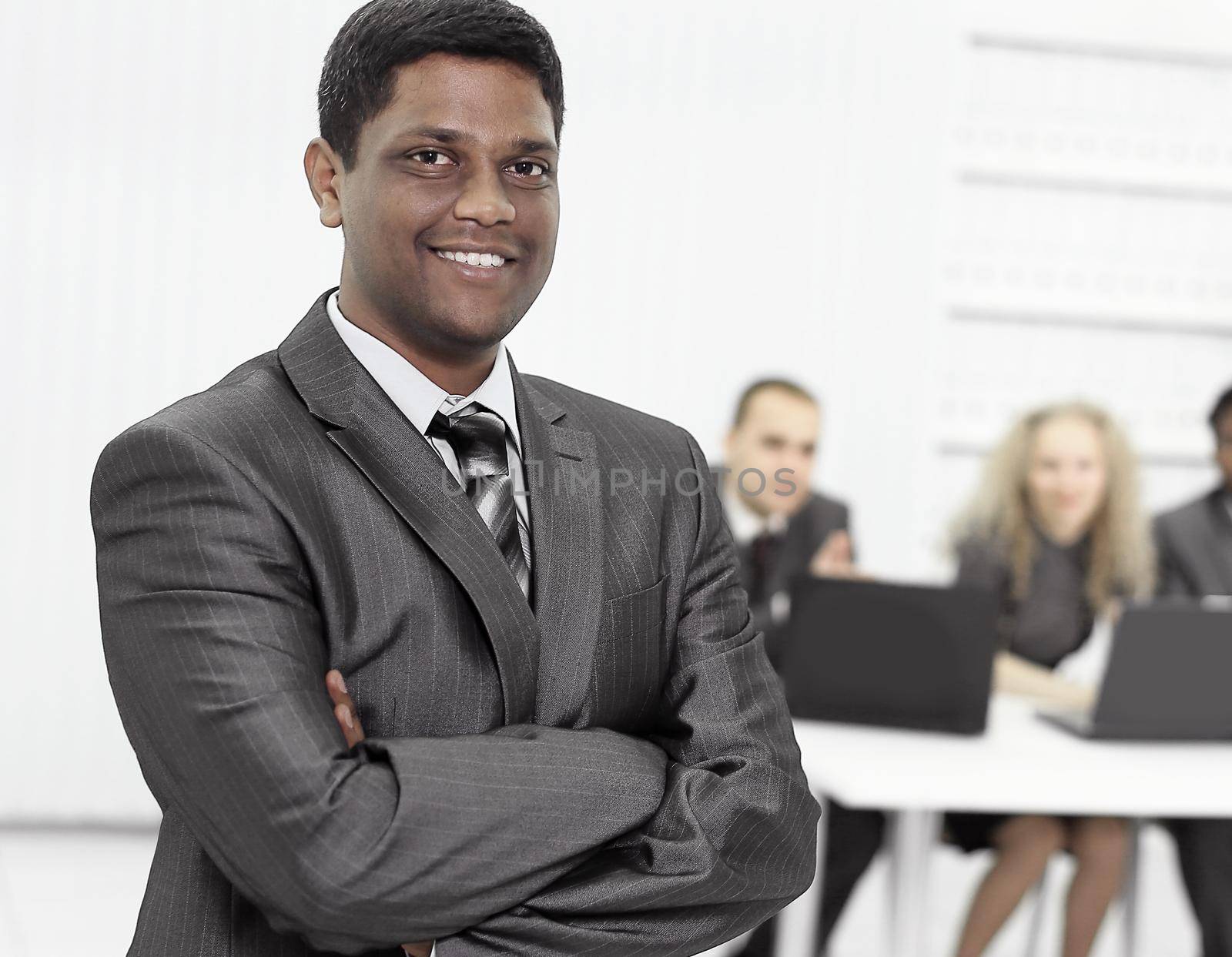 portrait of successful young businessman on background of office.