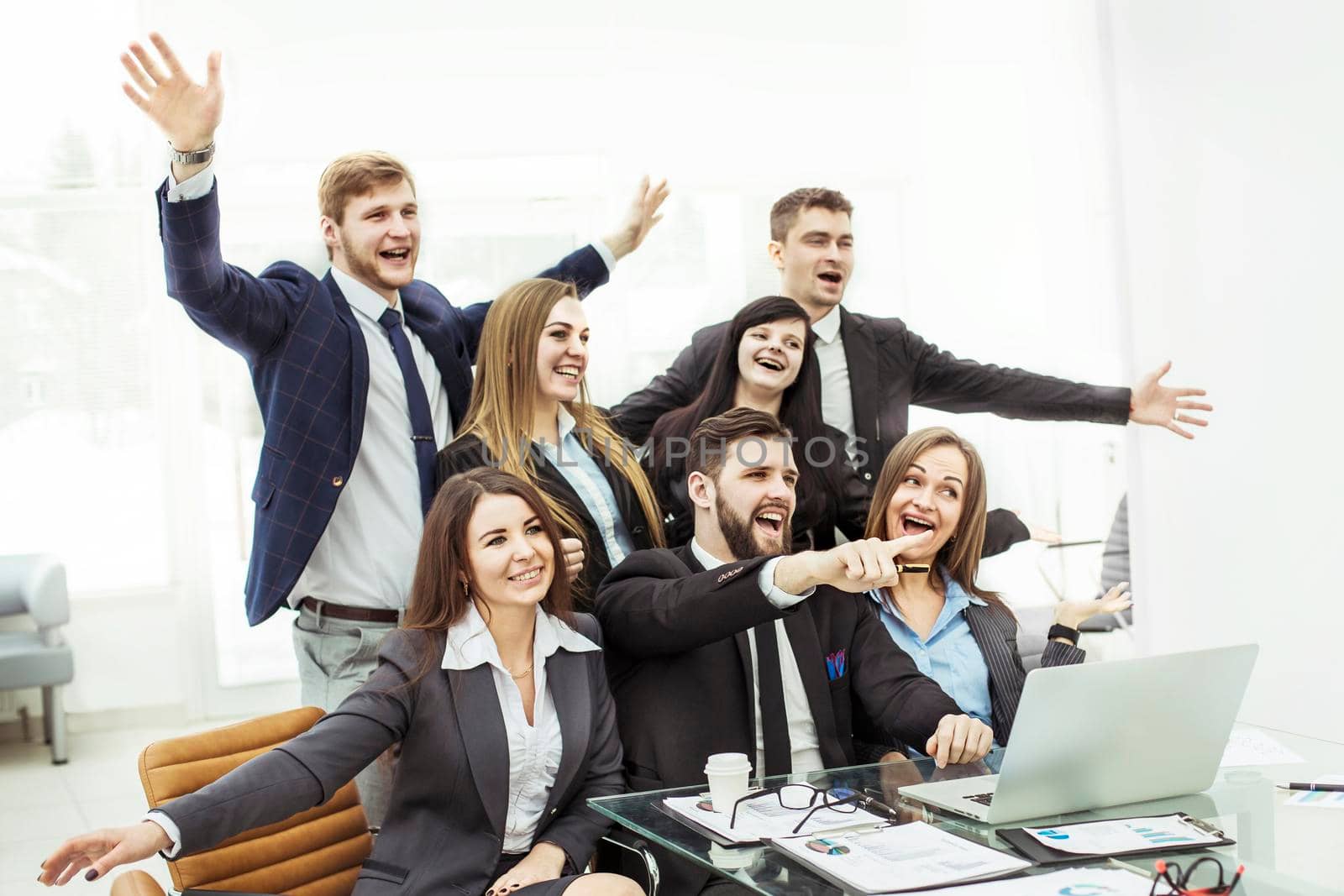 concept of business success - cheering business team in the workplace in the office by SmartPhotoLab