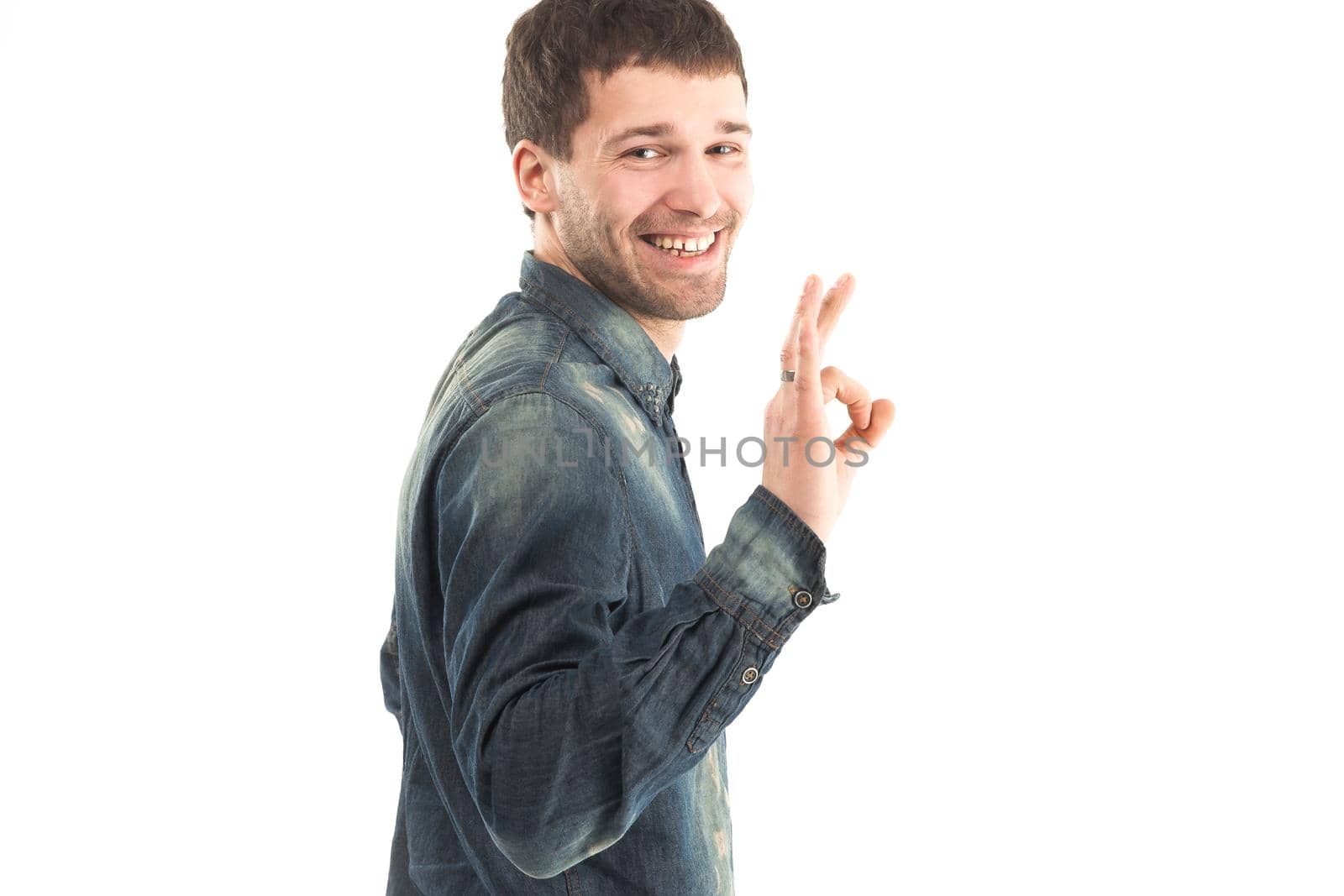 side view - stylish young man gestures OK a blank banner.the photo has a place for your text