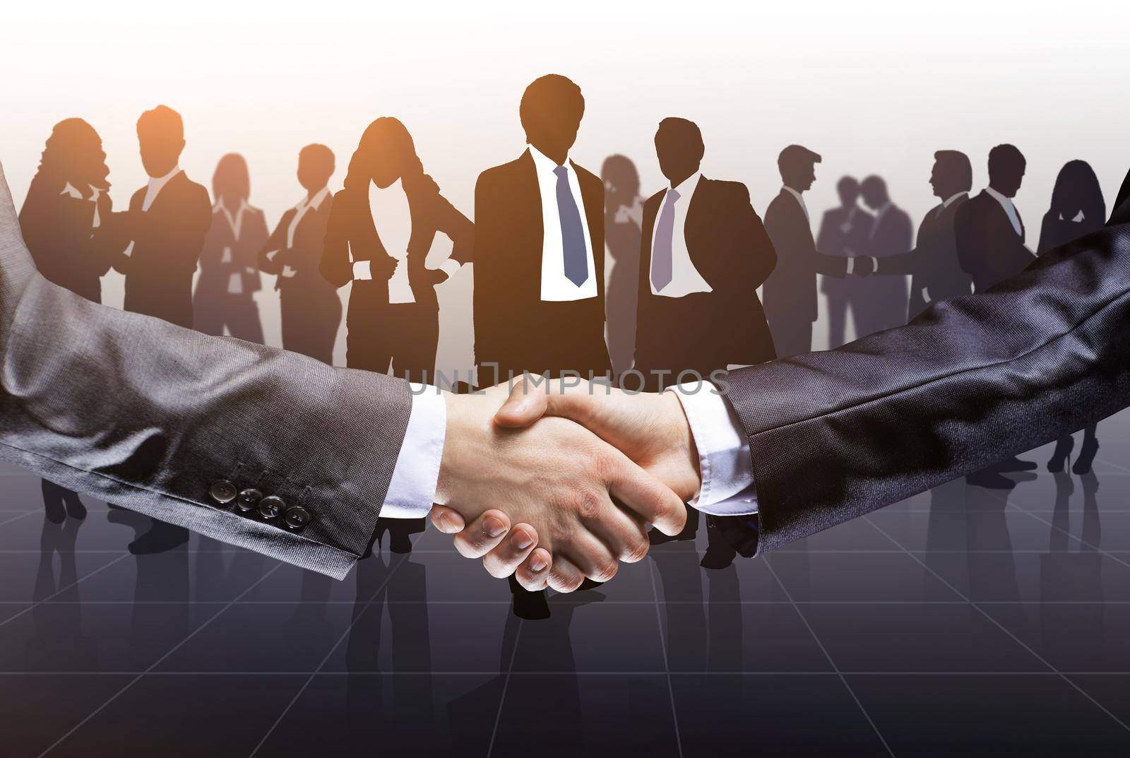 Close up. business people shaking hands on the background of business team by SmartPhotoLab