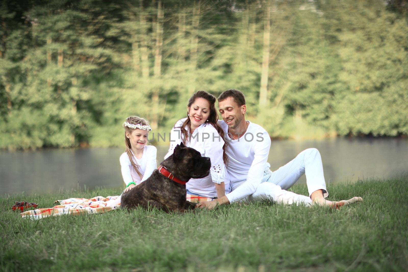 happy family with pet dog at picnic in a Sunny summer day. pregn by SmartPhotoLab