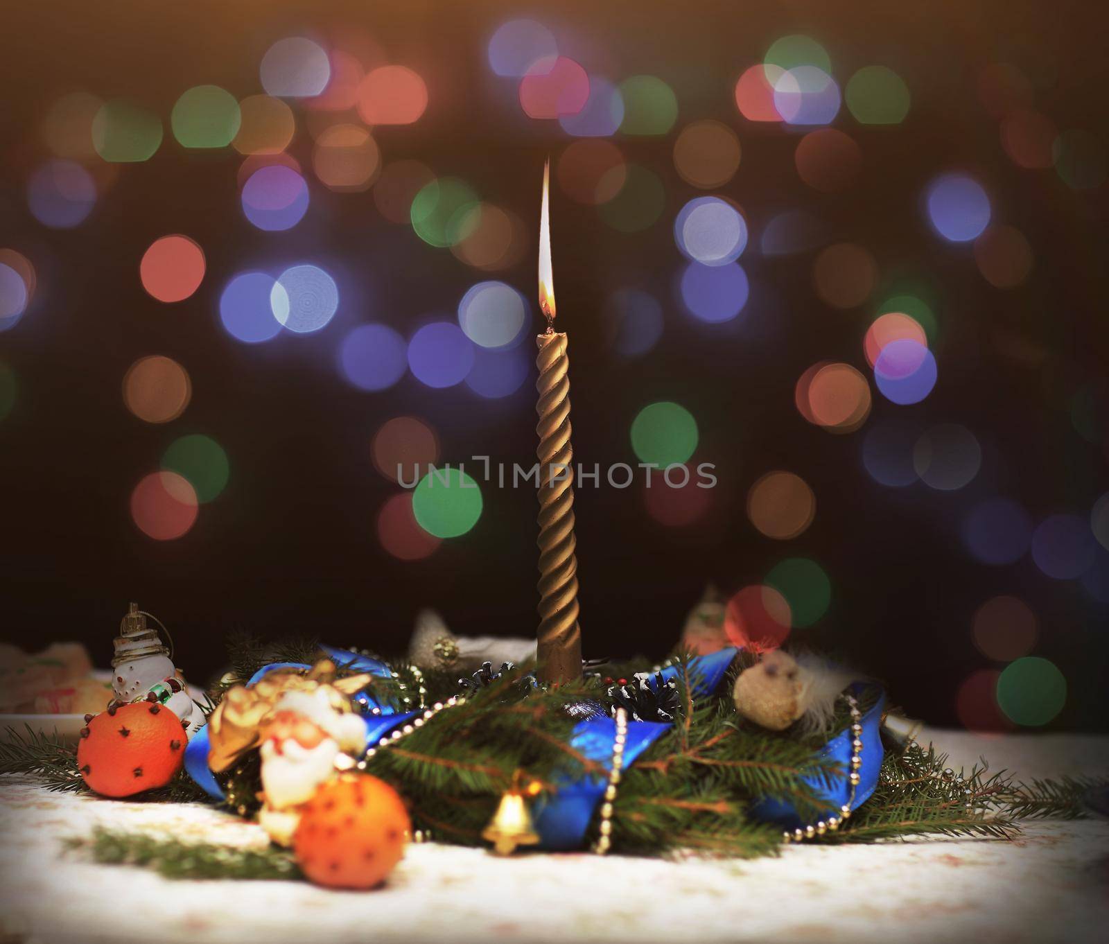 Christmas background.candle, Christmas tree twigs and oranges on the holiday table