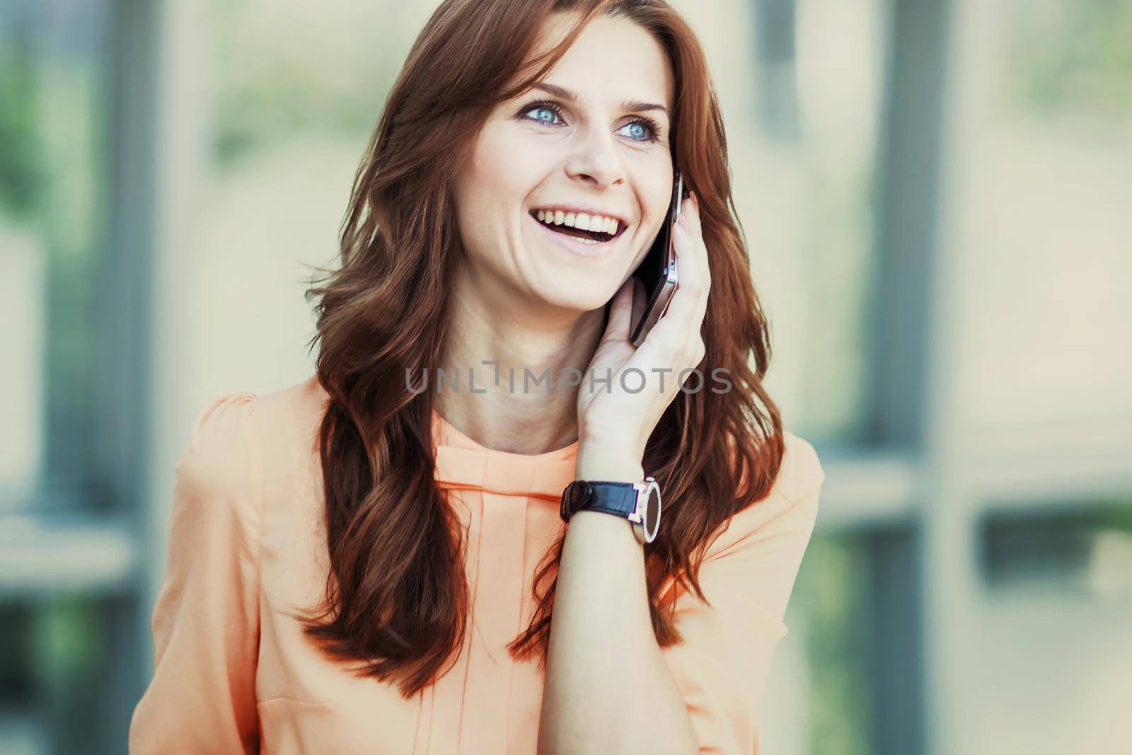 business woman talking on smartphone on background office.the photo has a empty space for your text