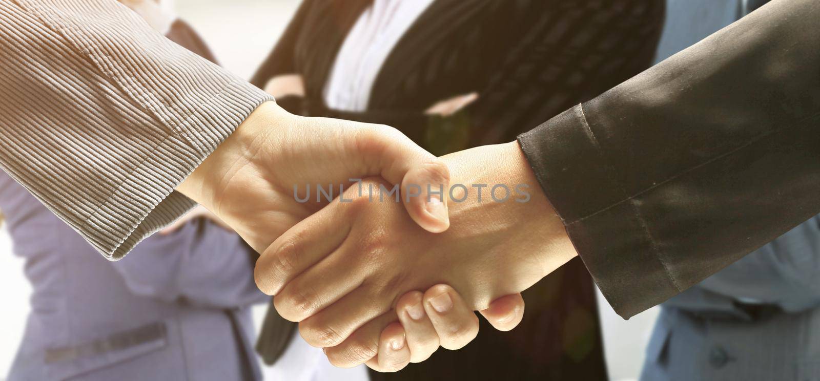 close up. confident businessmen shaking hands on background of business partners.concept of partnership