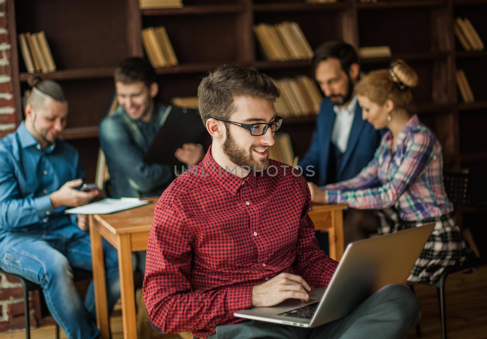 in the foreground the successful employee of the company with laptop on the background of business team