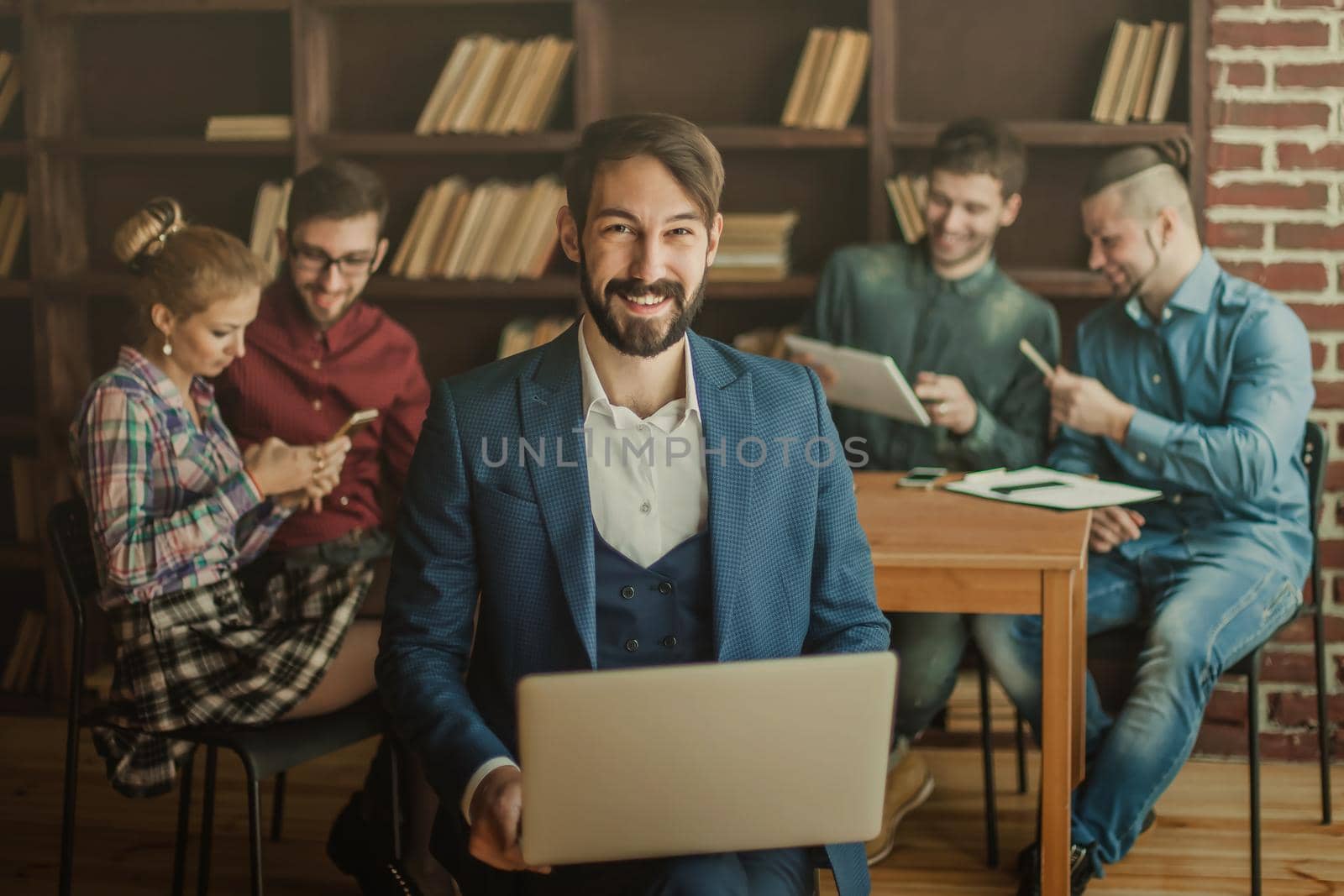 successful employee of the firm with a laptop and a business team discussing the current problems of the company