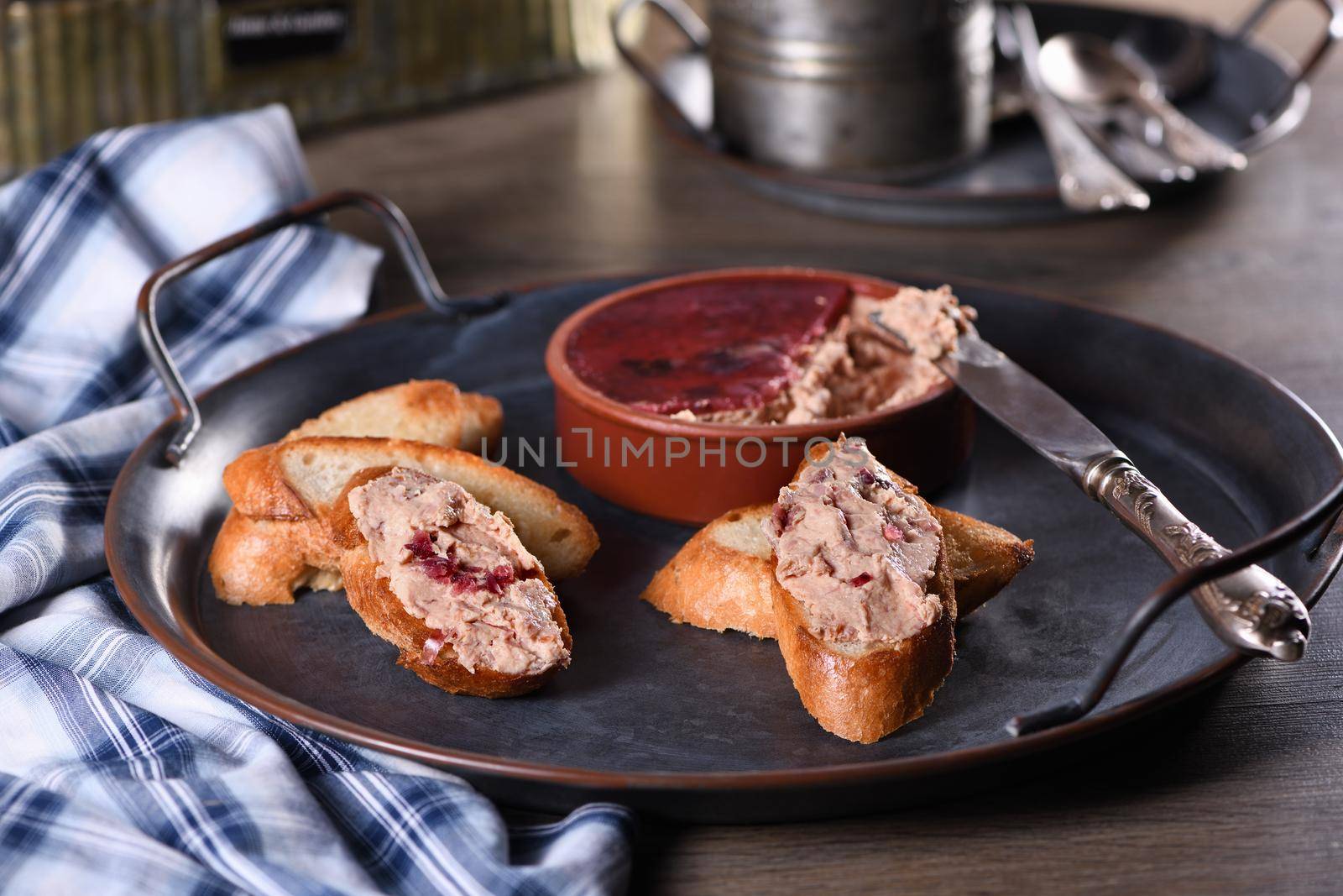  Delicate chicken pate with mashed cranberries spread on toasted baguette slices. Country style food.