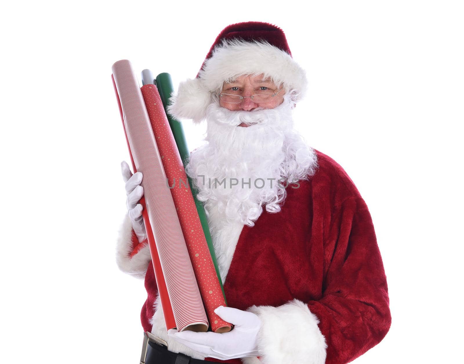 Santa Claus holding several rolls of Christmas gift wrapping paper, isolated on whtie.