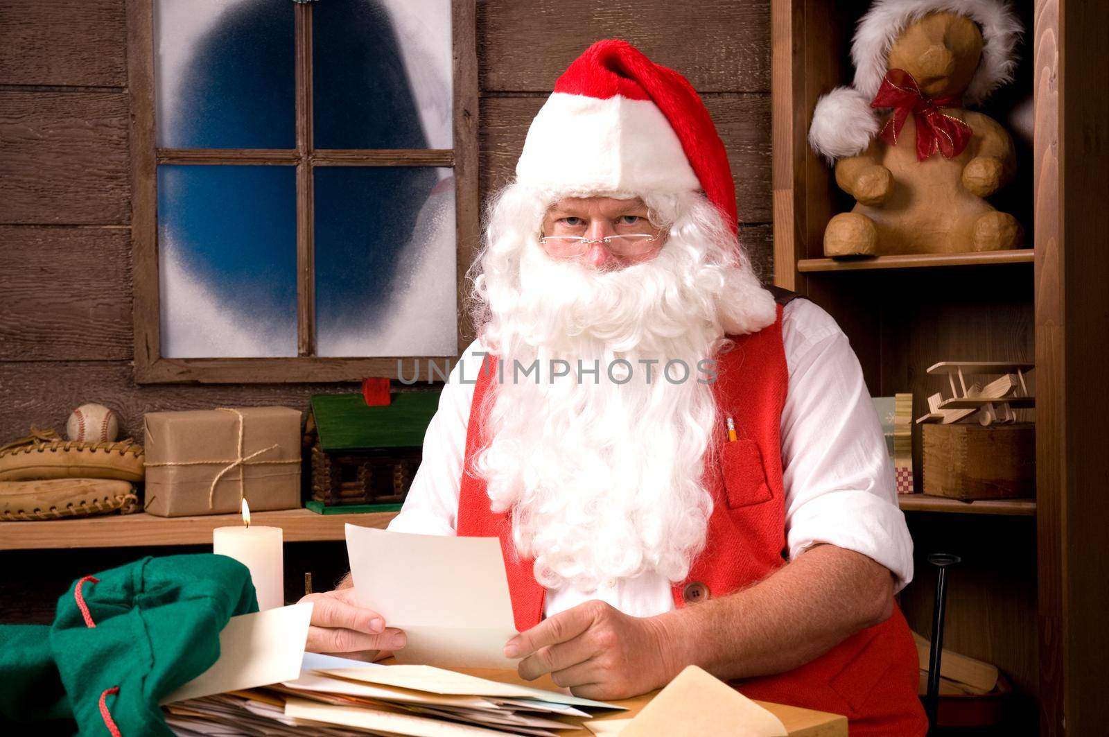 Santa Claus Sitting in His Workshop reading a letter. Horizontal  Composition.