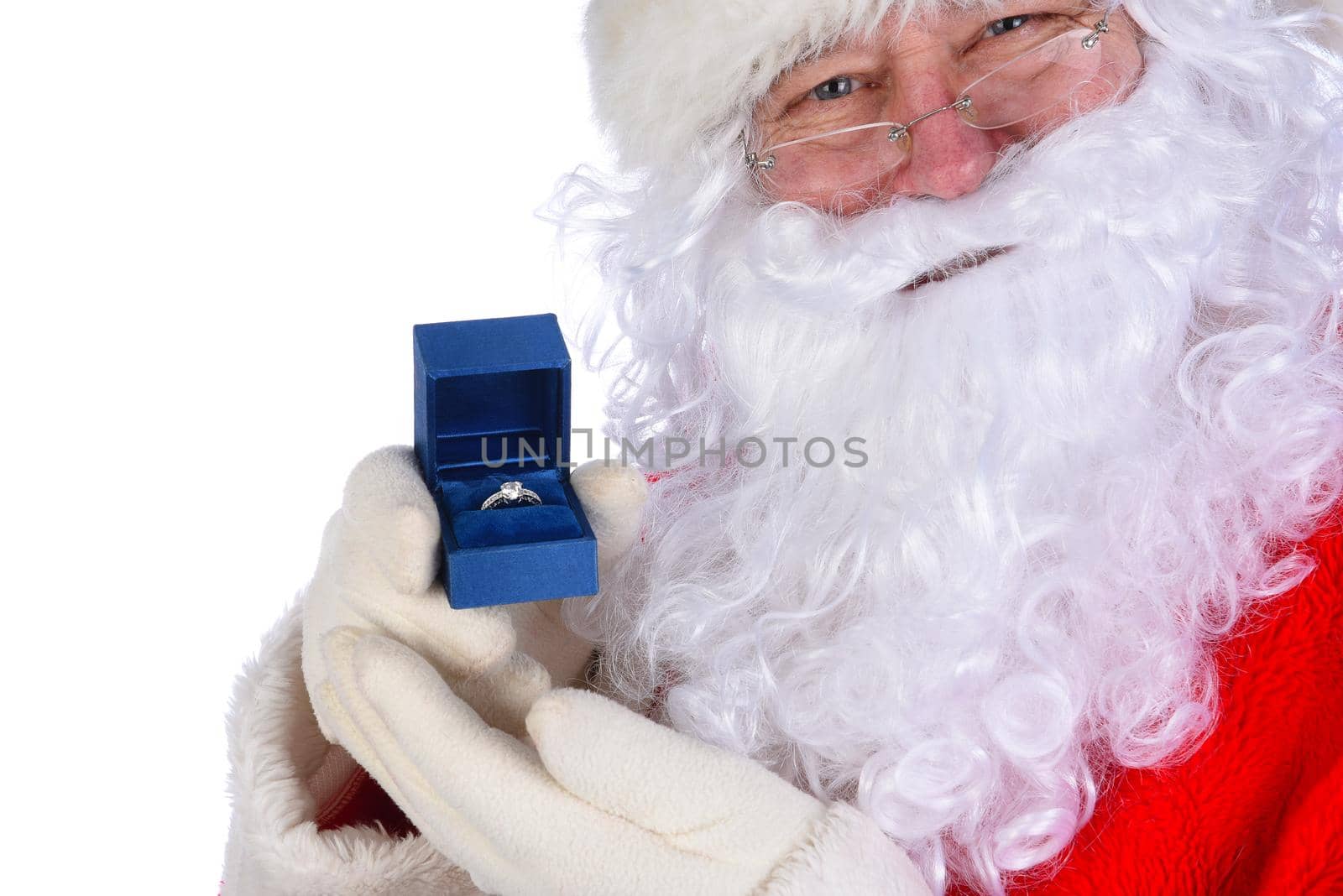 Santa Claus holding a diamond engagement ring in a blue box closeup next to his face.
