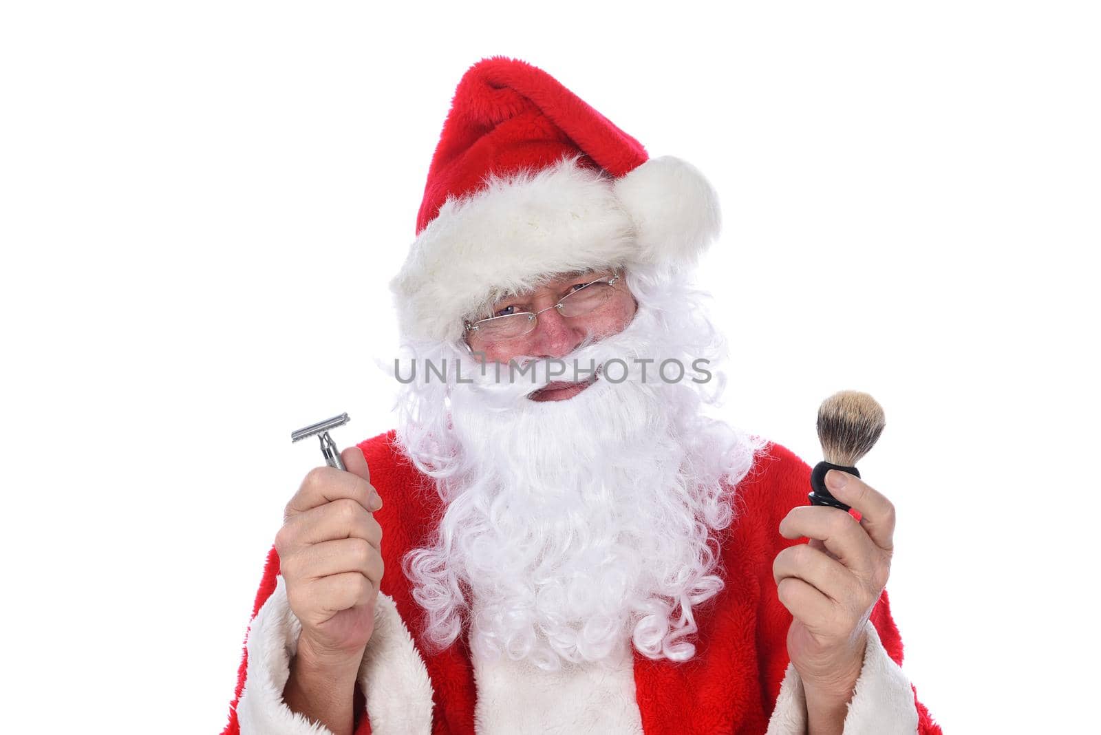 Closeup of Santa Claus holding a razor and shaving brush, contemplating cutting off his beard.
