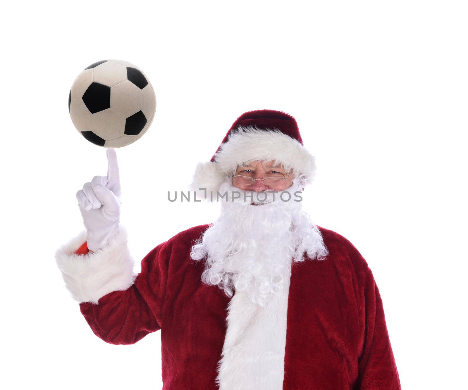 Santa Claus with his index finger pointing up with a soccer ball balanced on the tip, isolated on white.