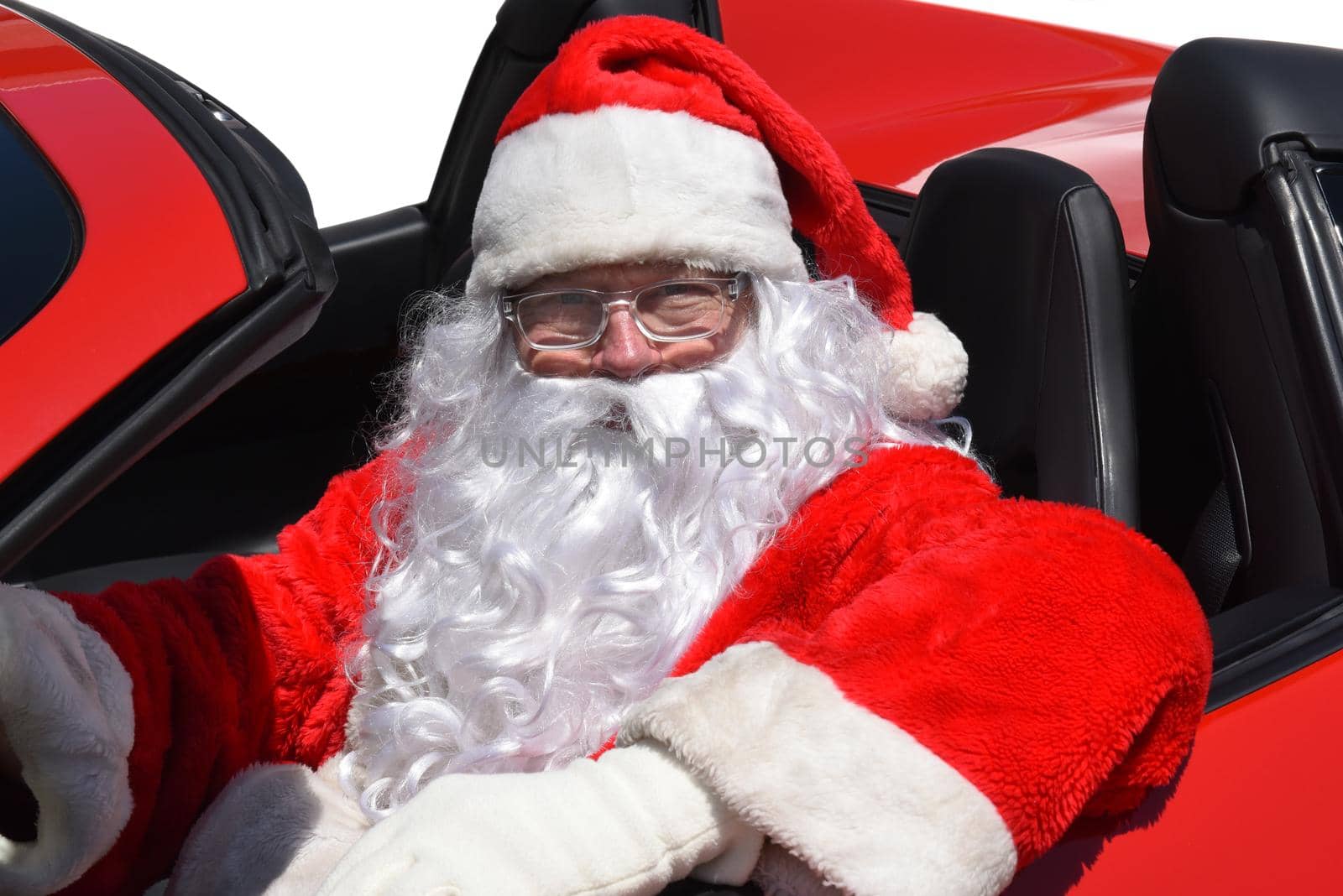 Closeup of Santa Claus sitting in his brand new red sports car.