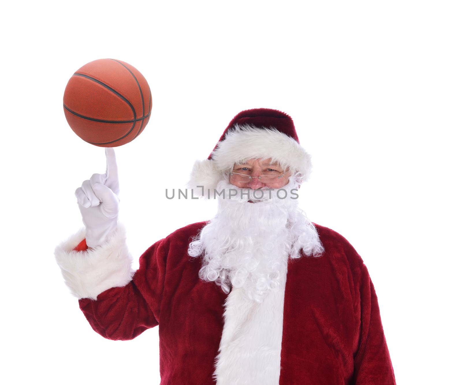 Santa Claus with his index finger pointing up with a basketball balanced on the tip, isolated on white.