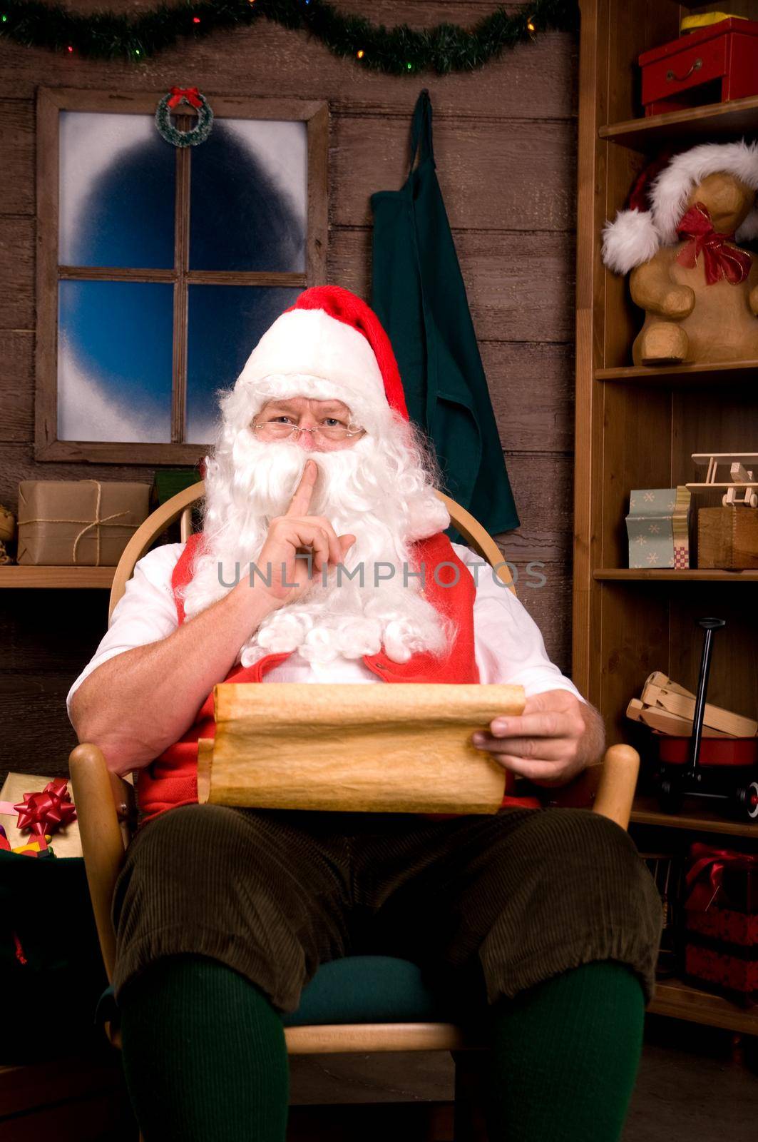 Santa Claus in Rocking Chair with Naughty List Going Shh. Vertical Composition