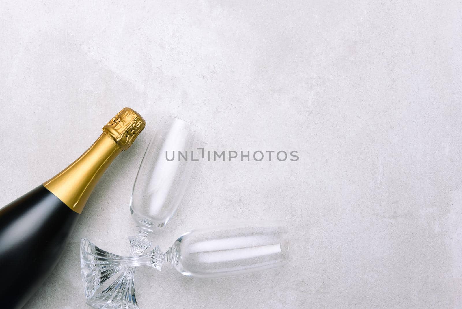 Champagne bottle and glasses on light gray surface. Horizontal format with copy space.