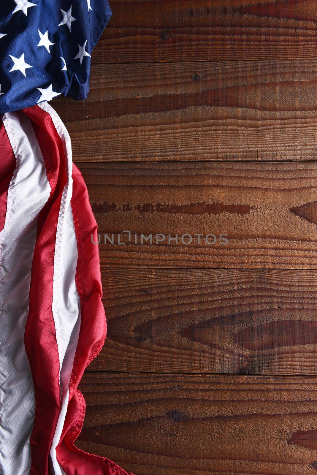 Closeup of an American flag on a dark wood table with copy space. Top view in horizontal format. 