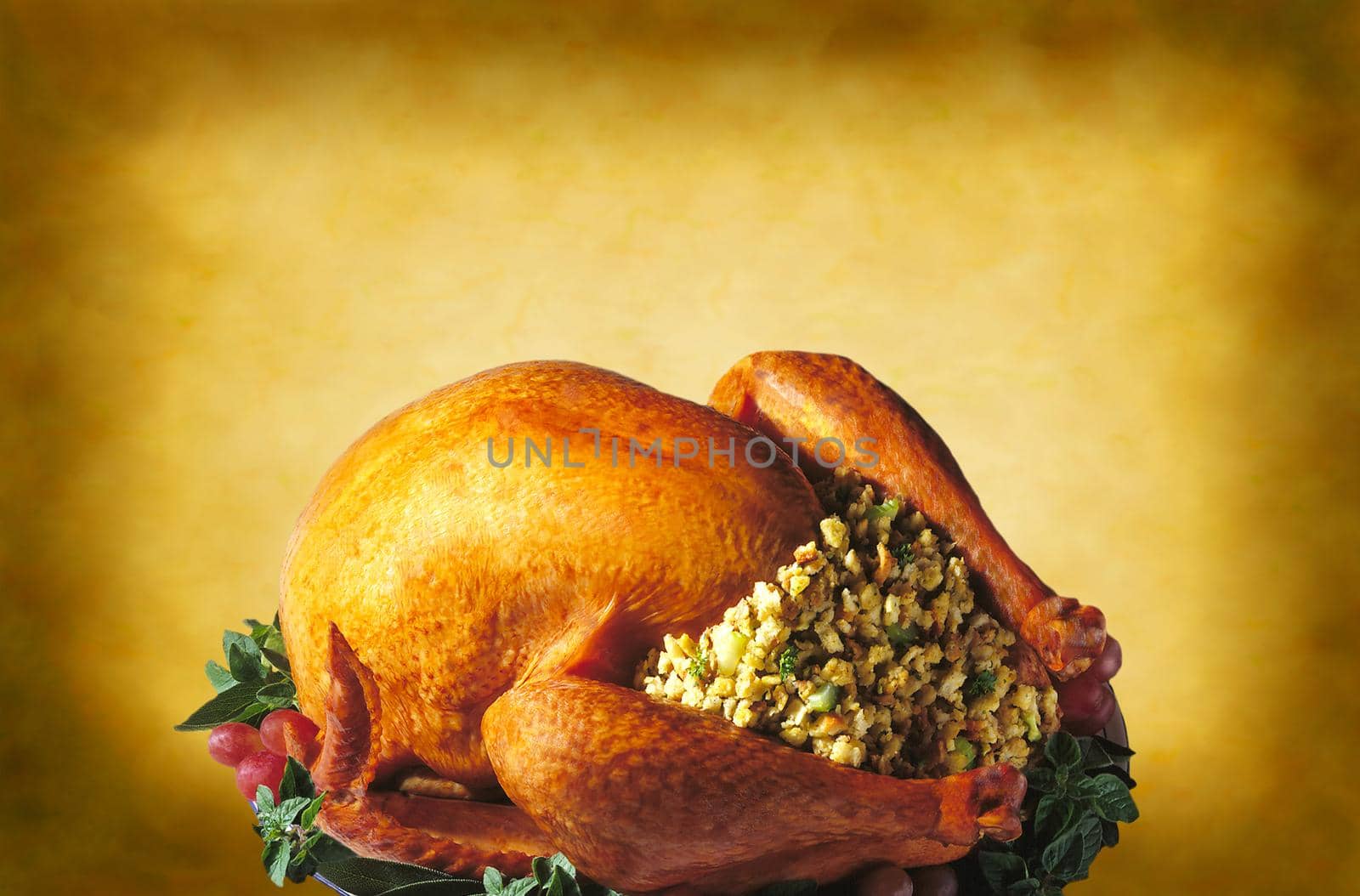 A roasted Thanksgiving turkey with all the trimmings on a warm yellow mottled background.