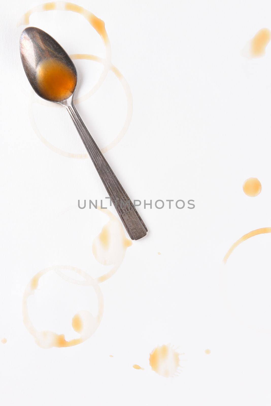 Spoon and coffee ring stains and drips on white paper, with copy space.