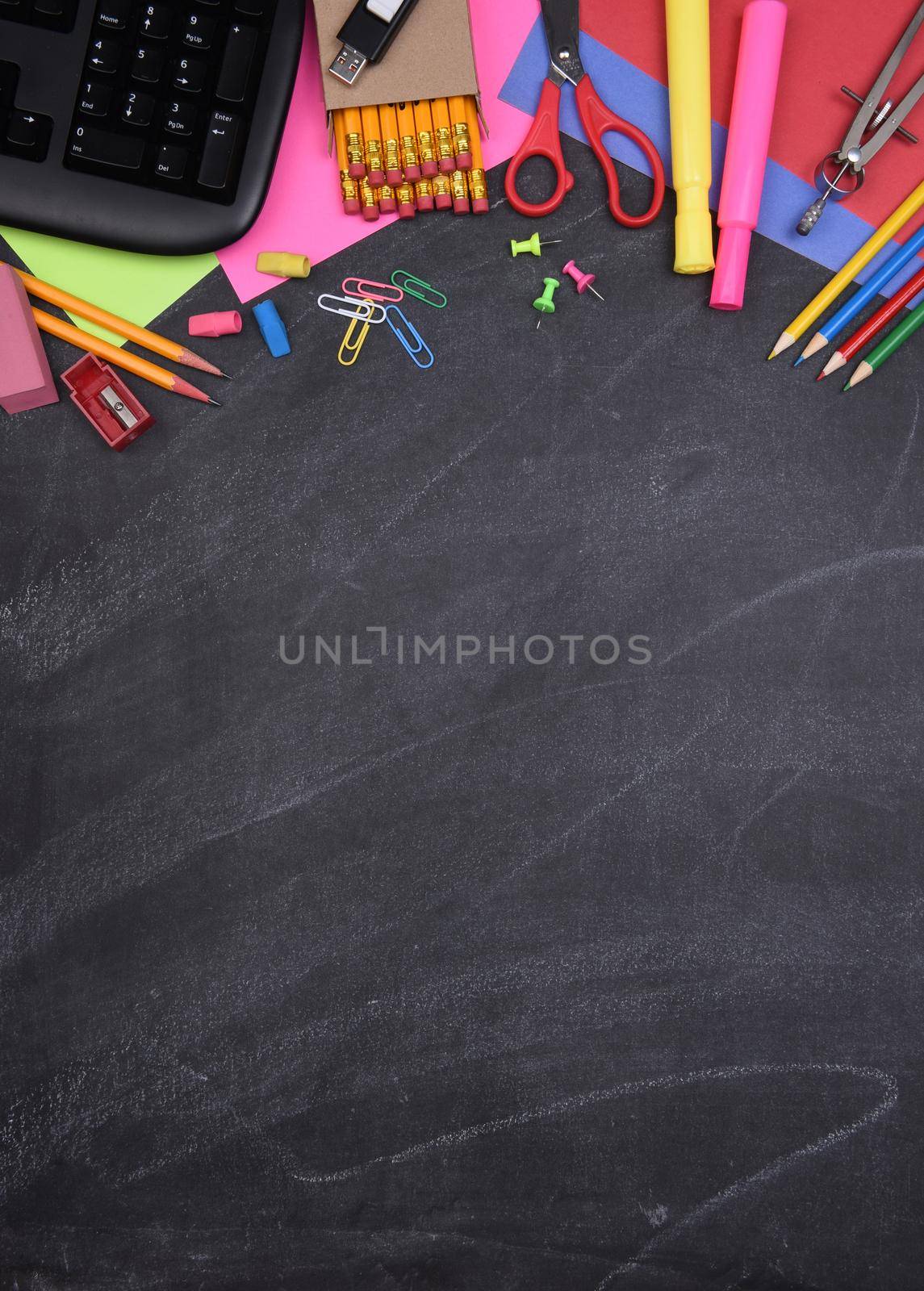 School Supplies: Still life on erased Chalkboard of assorted school supplies with copy space.