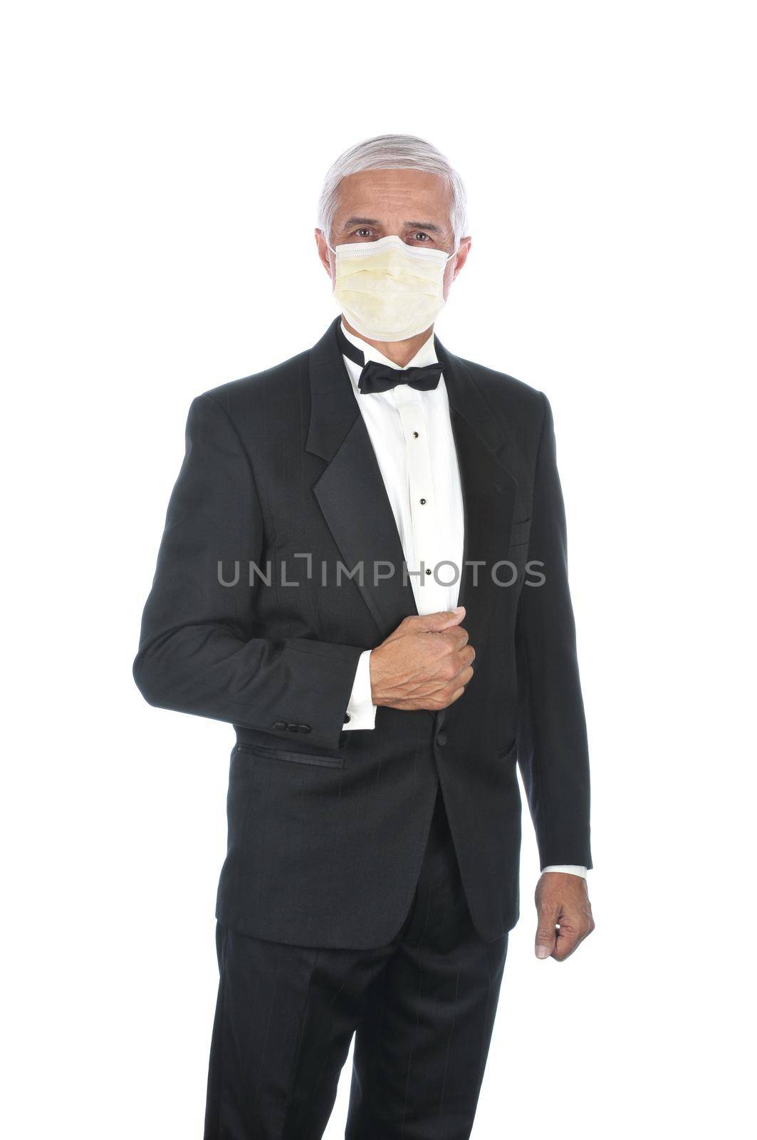 Mature Adult Male Wearing Tuxedo and Covid-19 protective mask, holding lapel and one hand at side, isolated on white. by sCukrov