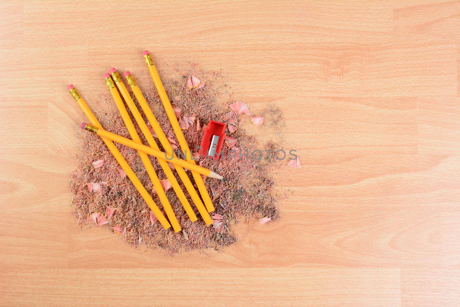 High angle view of yellow number 2 pencils on a school desk with a sharpener and shavings. Horizontal with copy space. Back to school concept.