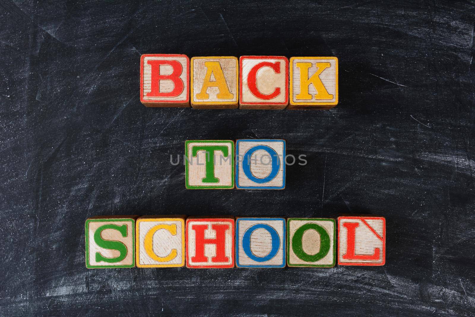 Childrens blocks spelling out Back To School on a chalk board. Horizontal format.