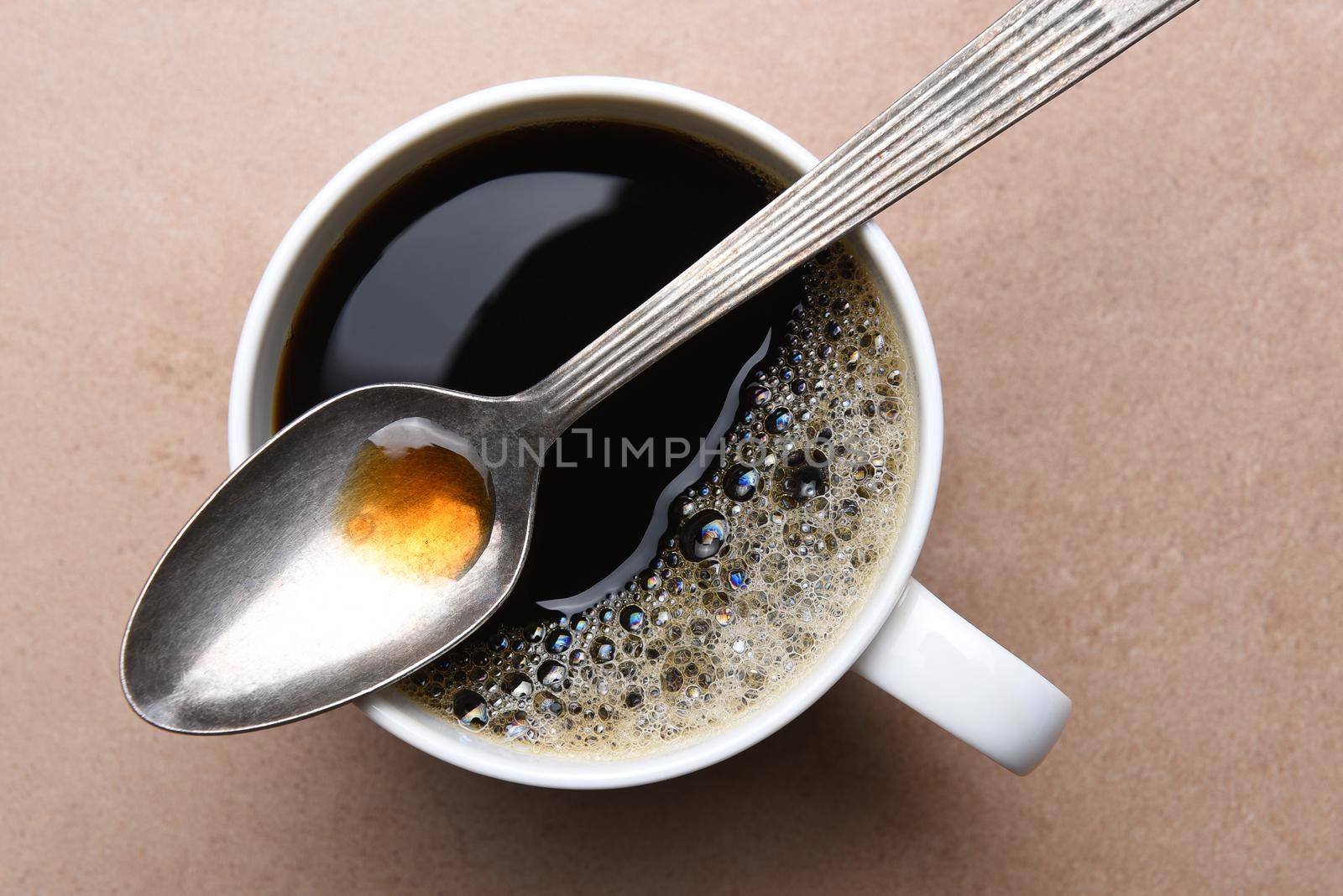 Spoon Laying Across the Top of a Coffee Mug by sCukrov