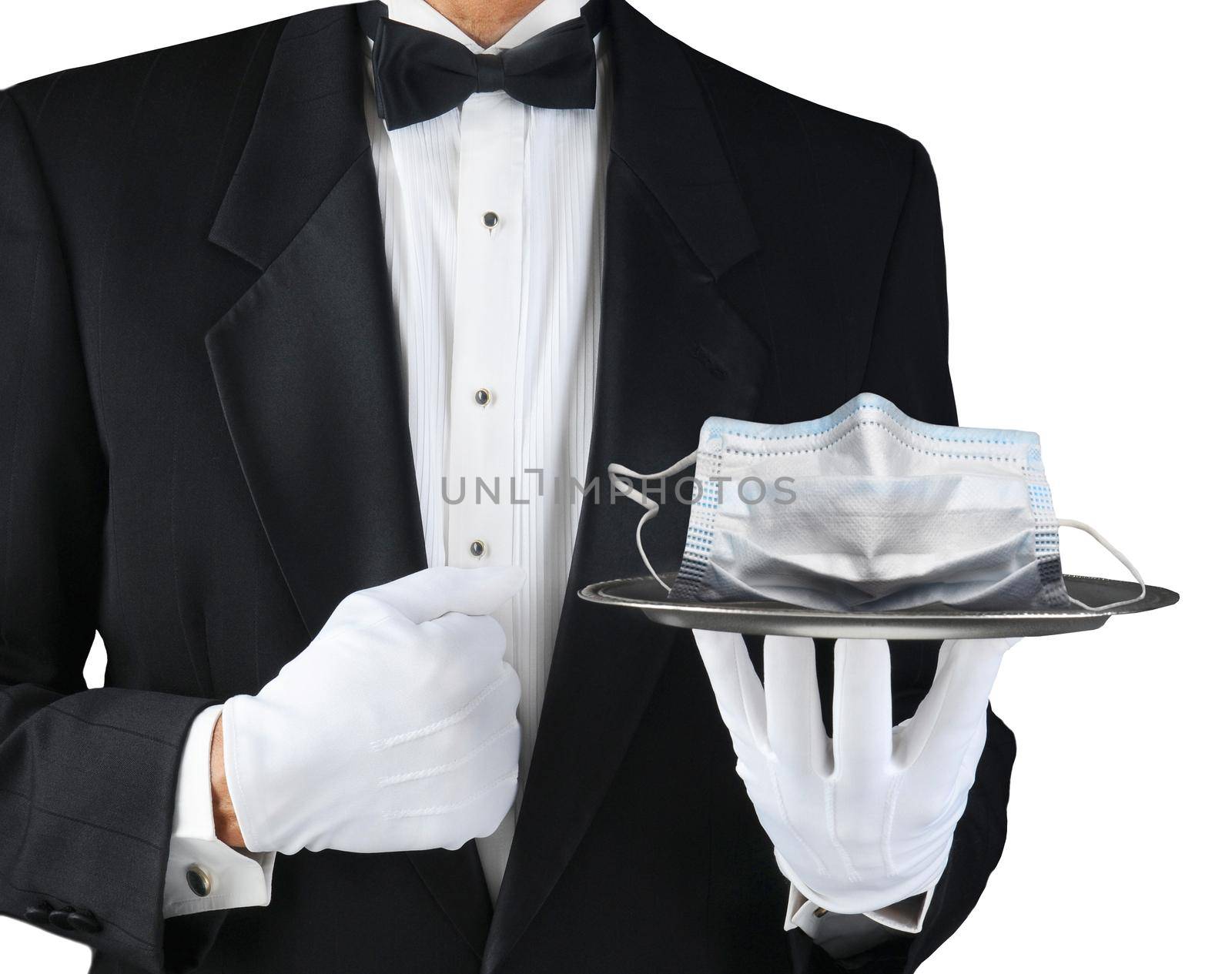 A tuxedo wearing waiter holding a silver tray With A COVID-19 mask. Horizontal format on white. by sCukrov