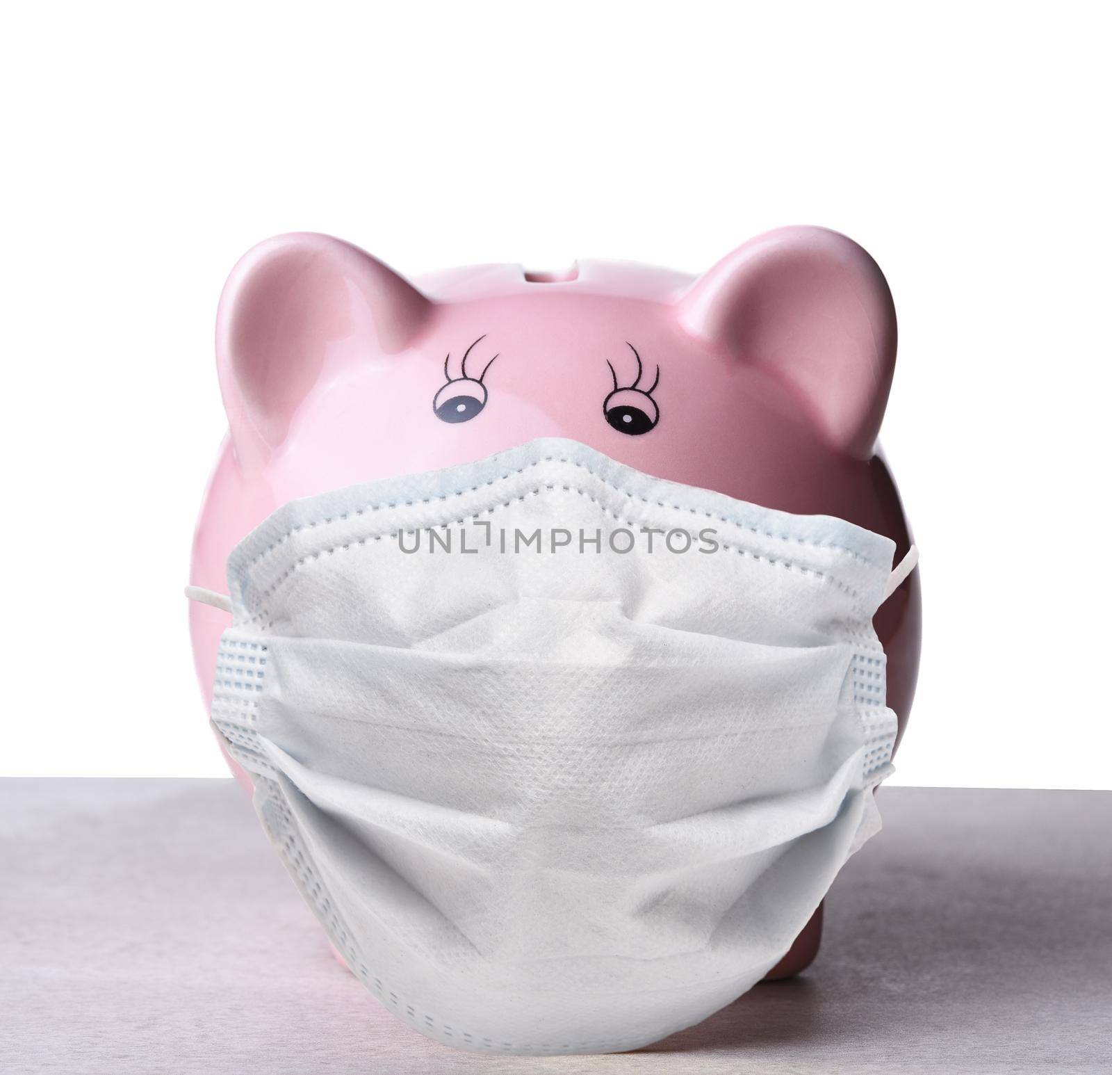 Closeup of a pink piggy bank wearing a COVID-19 surgical mask.