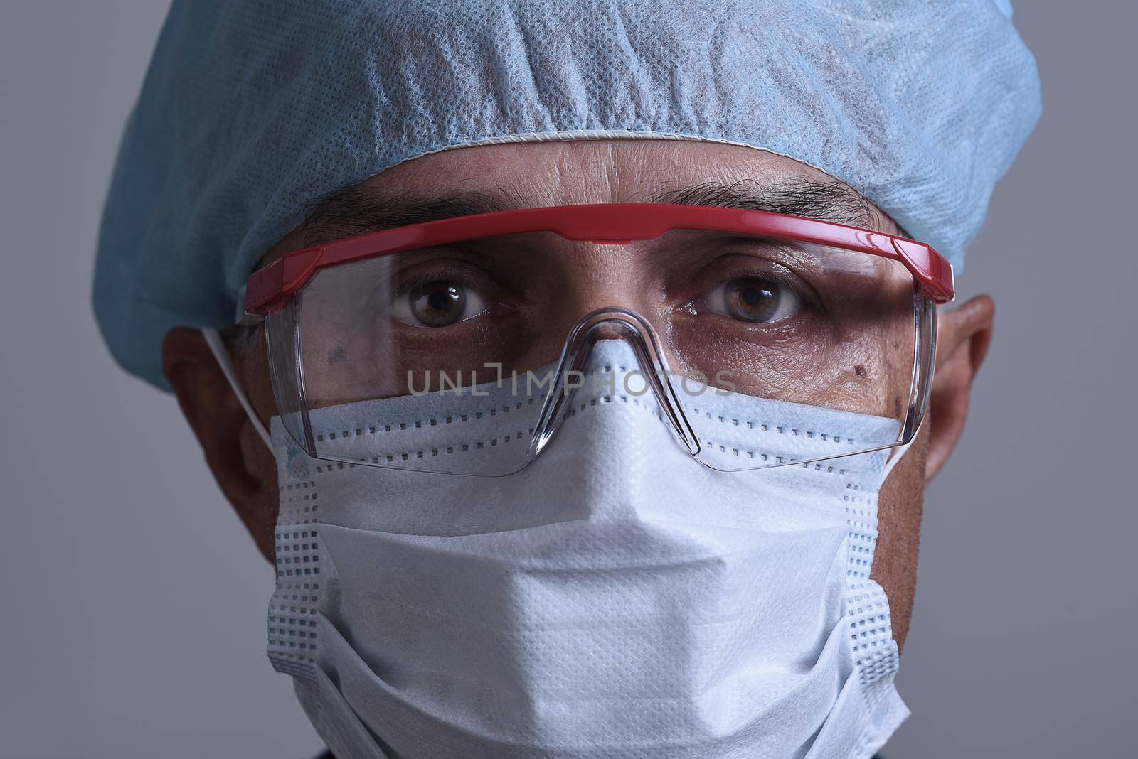 Portrait of a medical professional wearing his , Personal Protective Equipment, PPE. Closeup Head only.