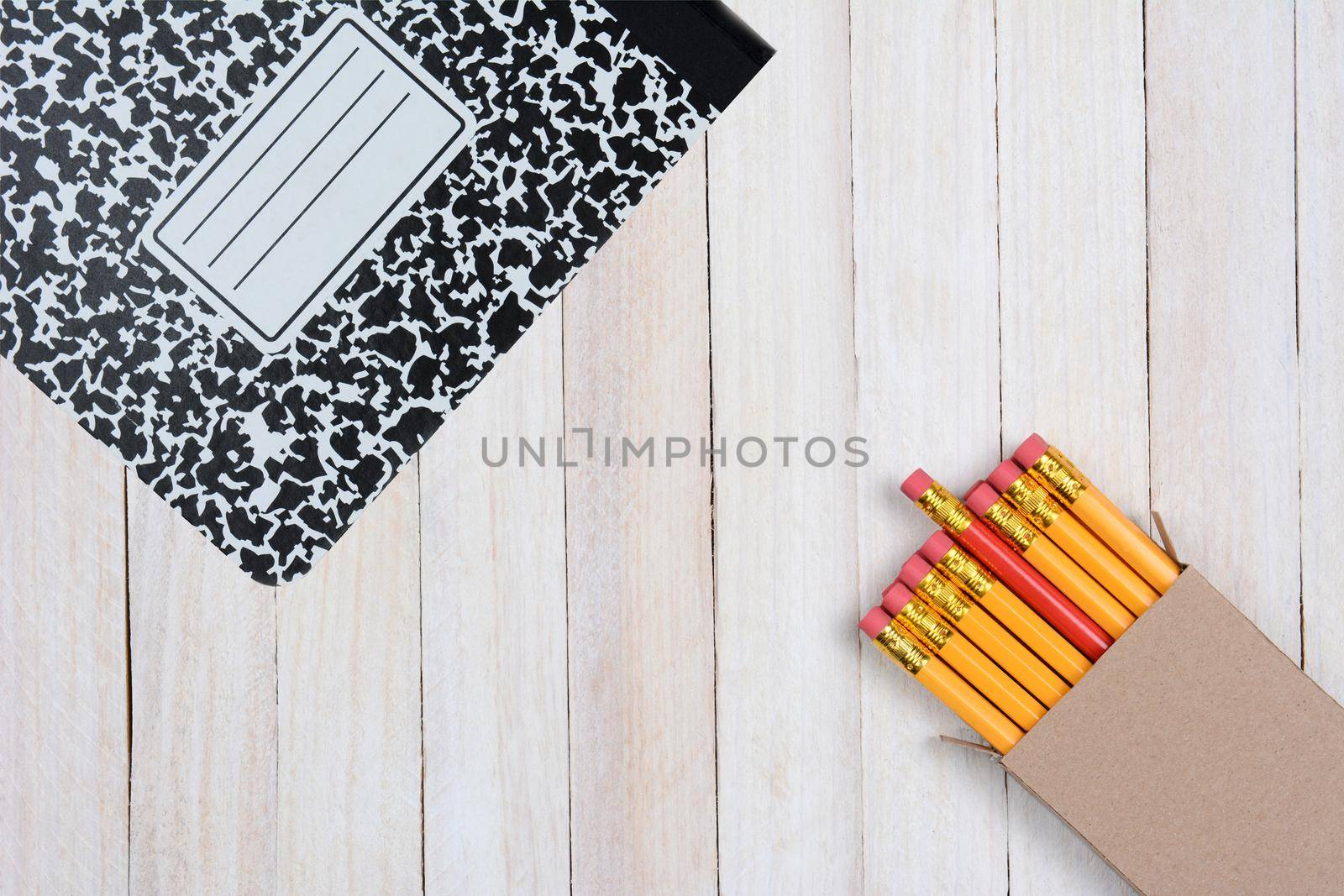 Pencils and Composition Book on Wood Surface by sCukrov
